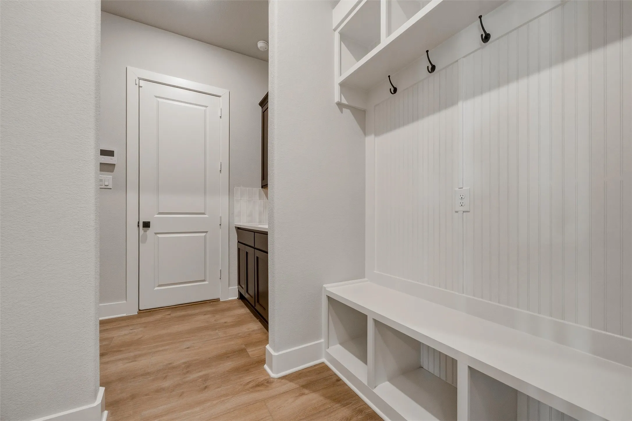 Built-in hall tree with beadboard backing, integrated storage bench, and upper shelving with hooks