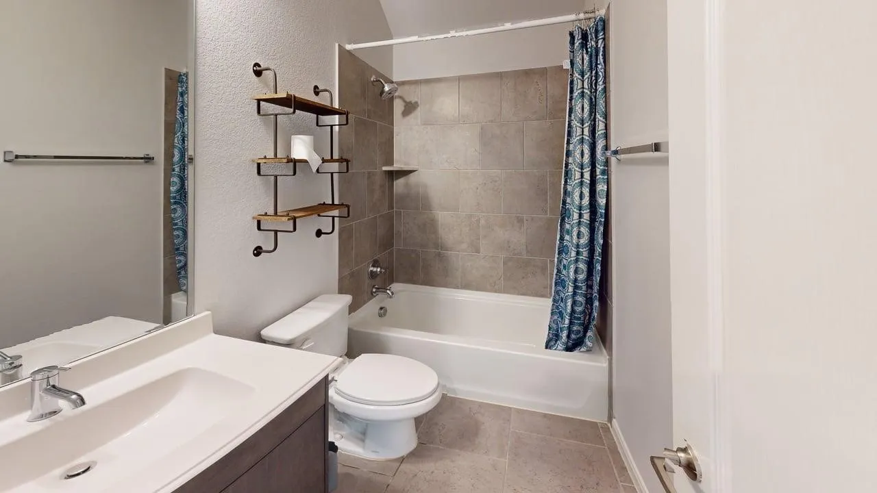 Bathroom featuring a white vanity with an integrated sink, chrome faucet, and expansive wall mirror