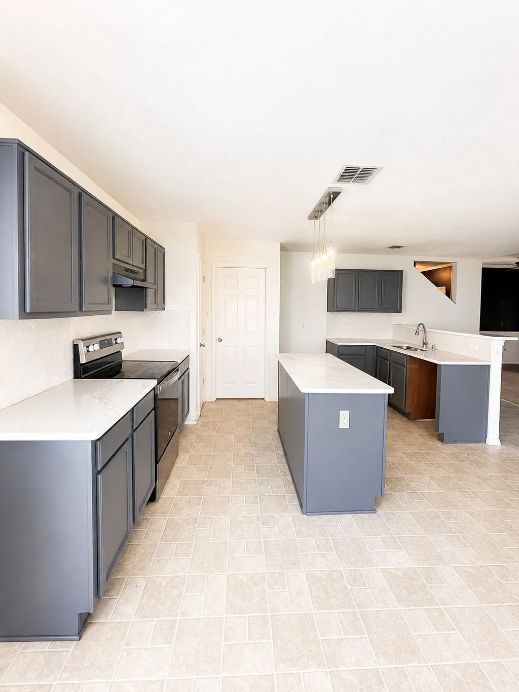 Kitchen featuring gray cabinetry, white countertops, stainless steel appliances, a center island, and tile flooring
