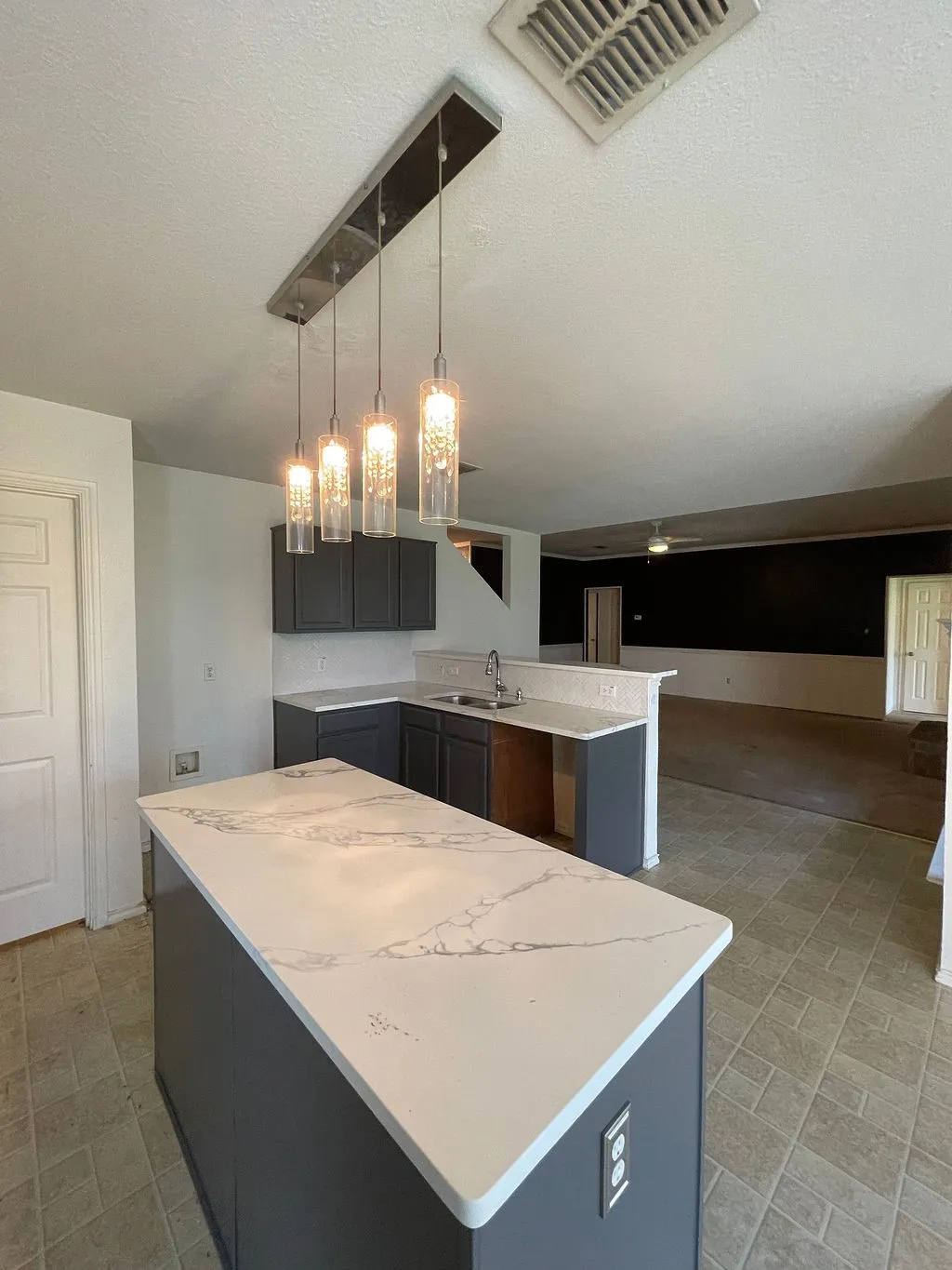 Kitchen island with a white patterned countertop and integrated electrical outlets