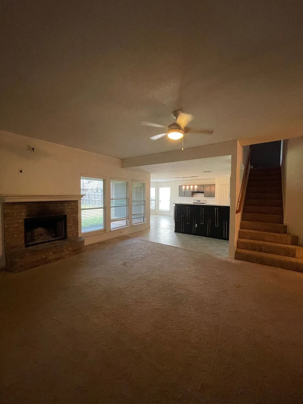original photo)living area featuring a brick fireplace, ceiling fan, and large windows