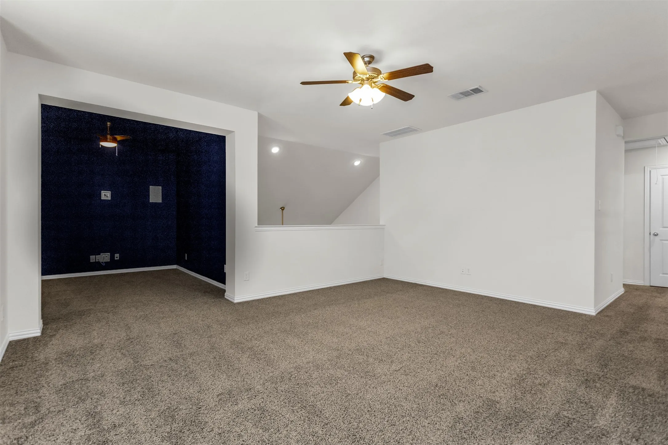 Carpeted secondary living space featuring a ceiling fan, recessed lighting, and a distinct alcove with dark blue textured walls and an additional ceiling fan
