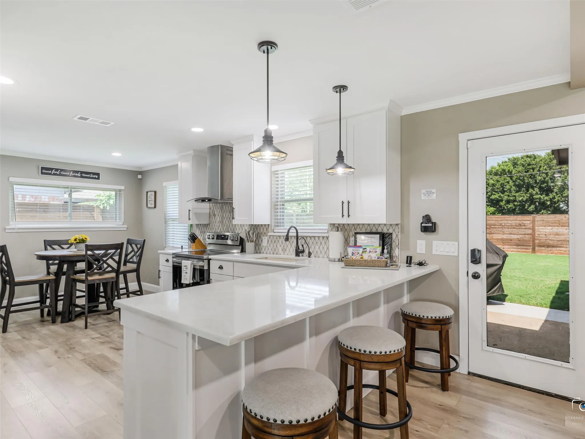 Kitchen with breakfast bar with designer pendant light fixtures