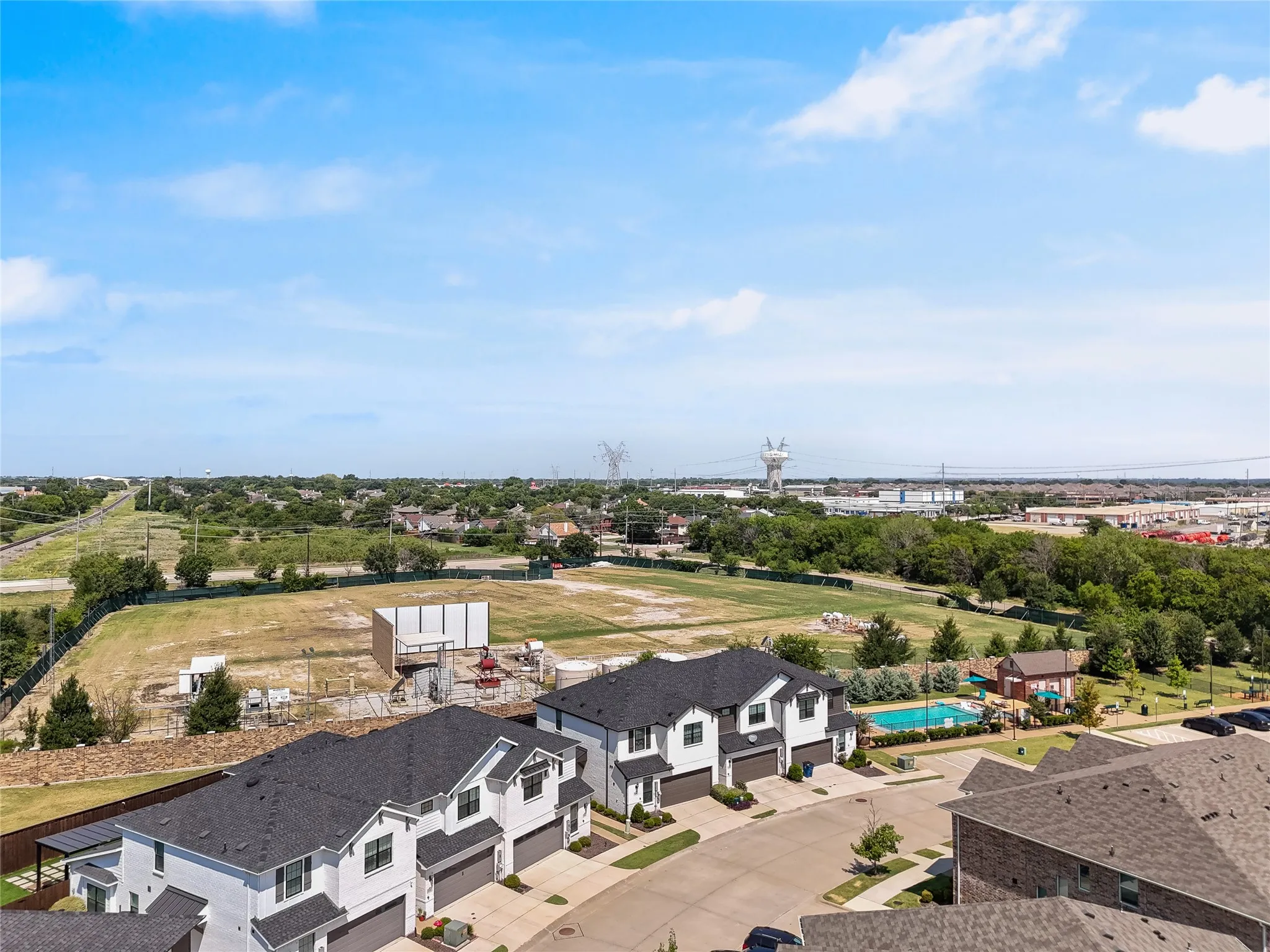 Contemporary townhome exteriors featuring dark shingle roofs and light-colored siding