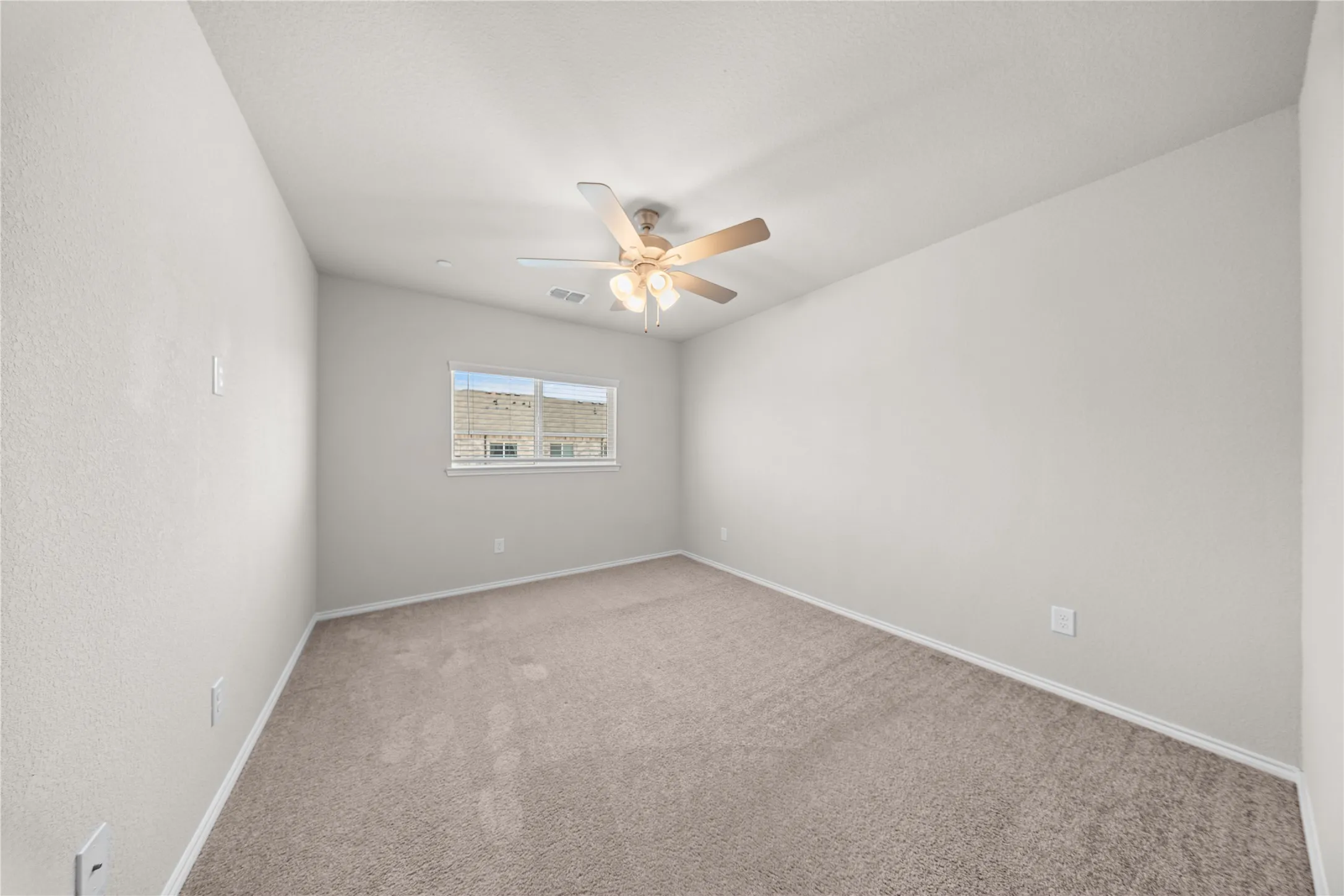 Carpeted room featuring a ceiling fan with integrated lighting, a window with white trim, and white baseboards