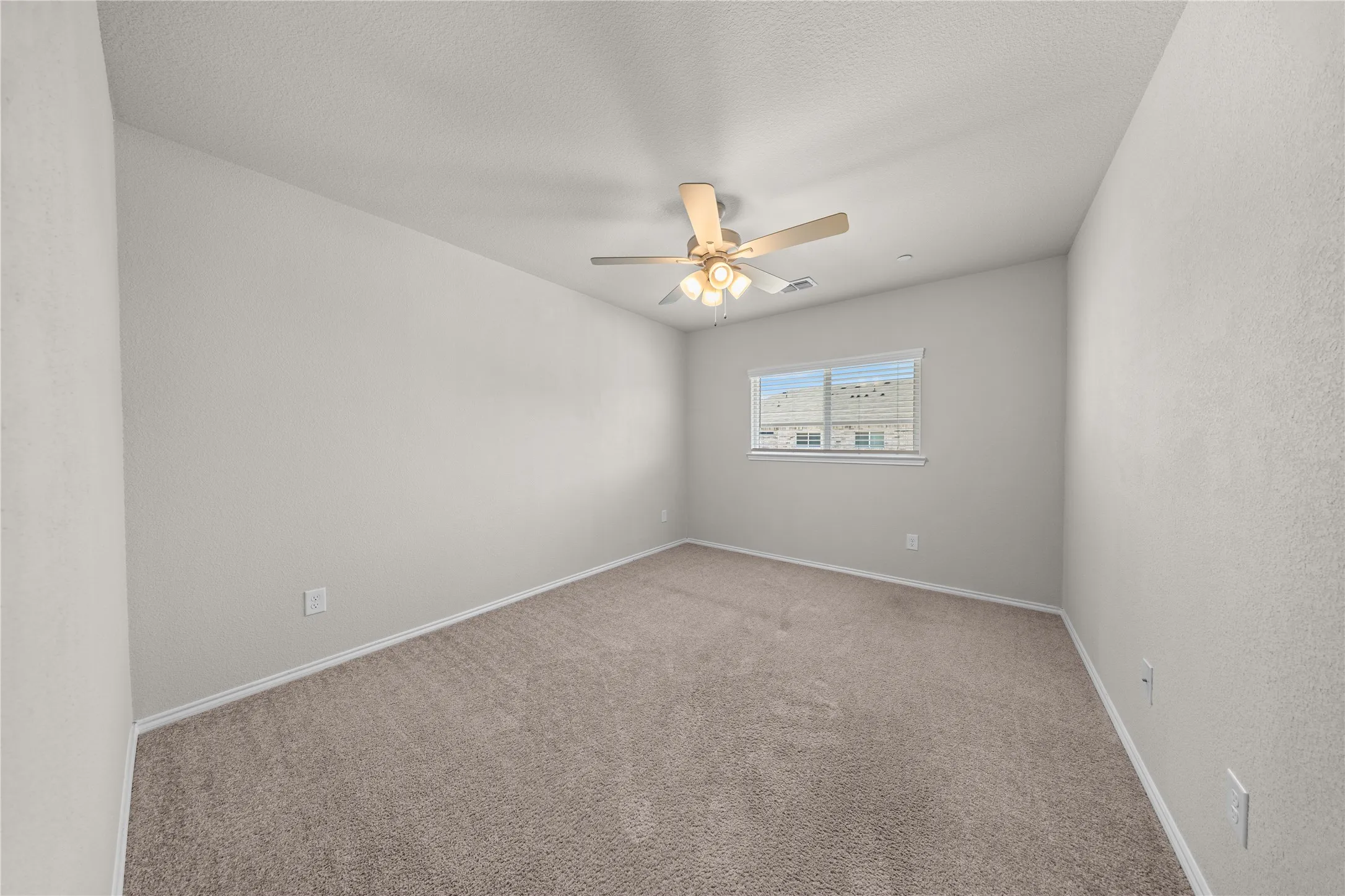 Carpeted room featuring a ceiling fan with integrated lighting, a single window with horizontal blinds, and neutral-toned walls