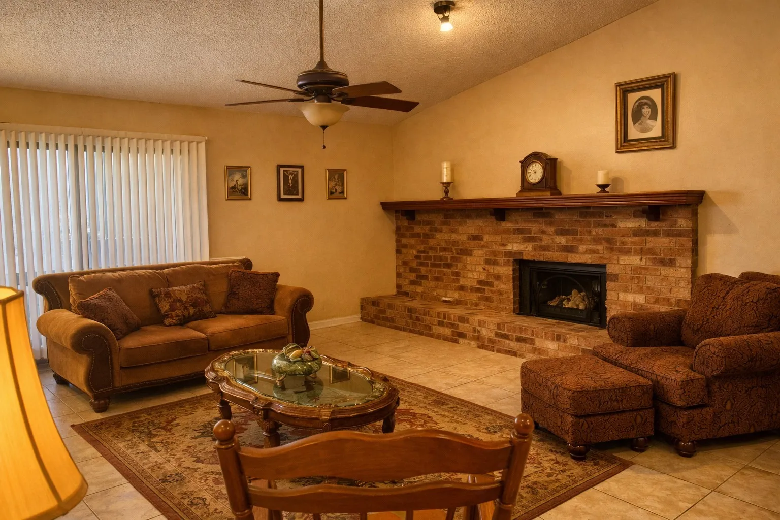 Spacious living area featuring a prominent brick fireplace with a wood mantel