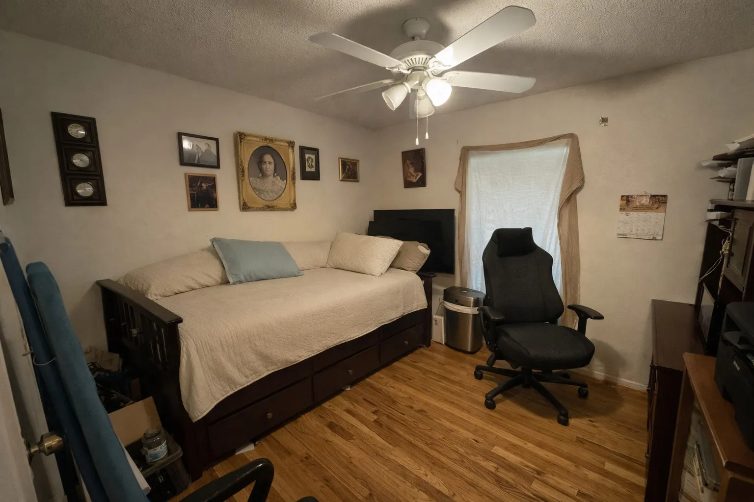 Room featuring wood-finish flooring and a ceiling fan with integrated lighting