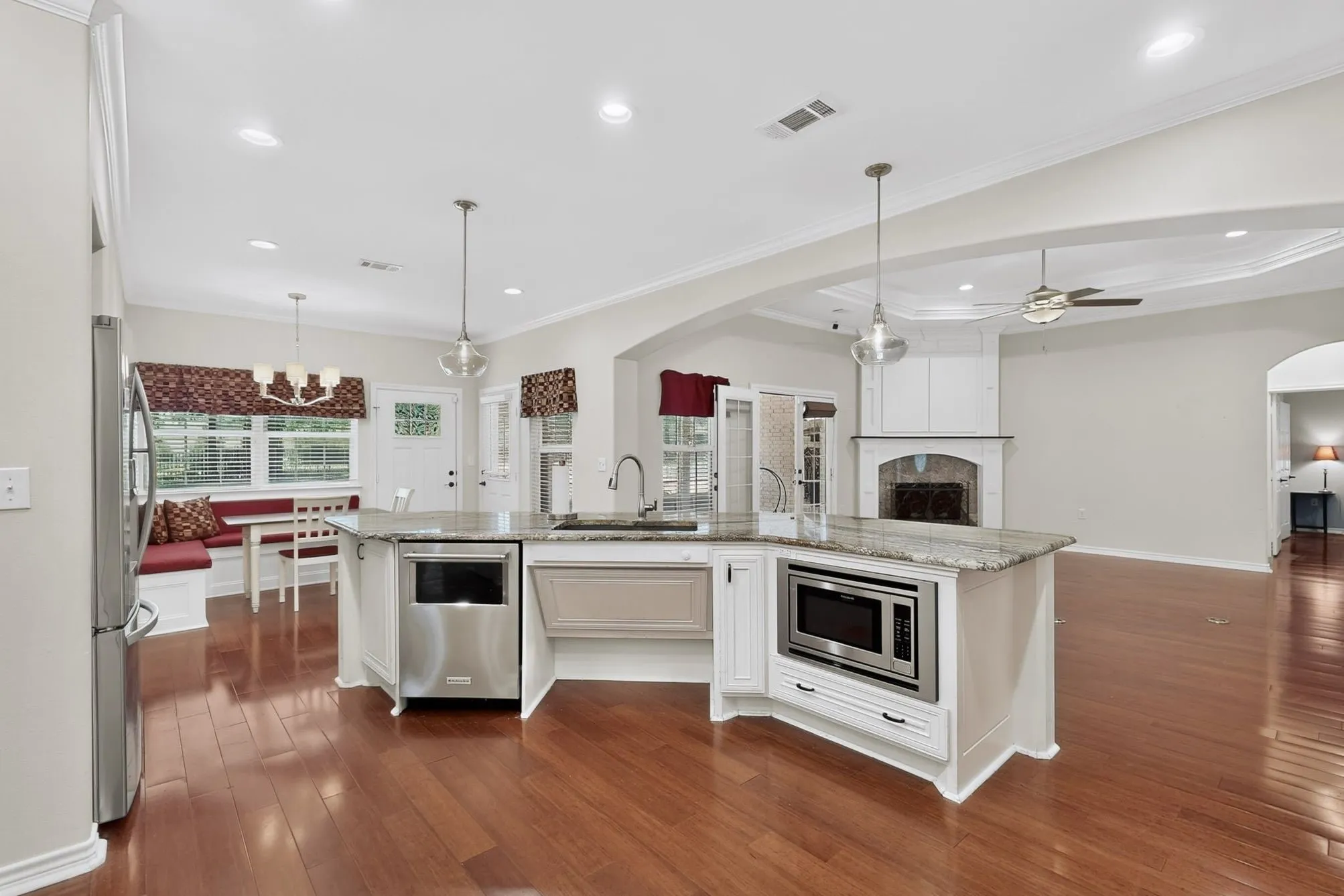 Kitchen featuring a central island with integrated microwave and dishwasher, granite countertops, and pendant lighting