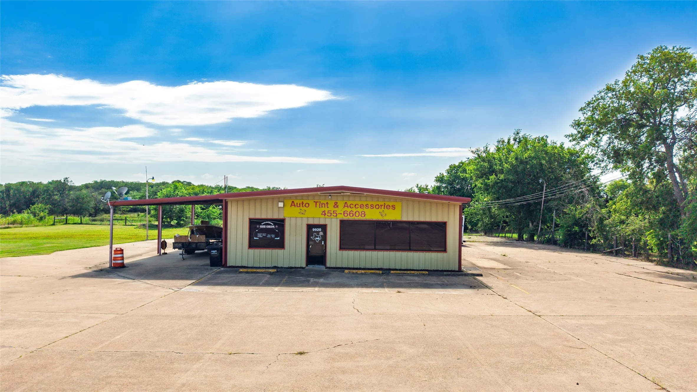 Commercial building featuring a light-colored exterior with an attached metal awning