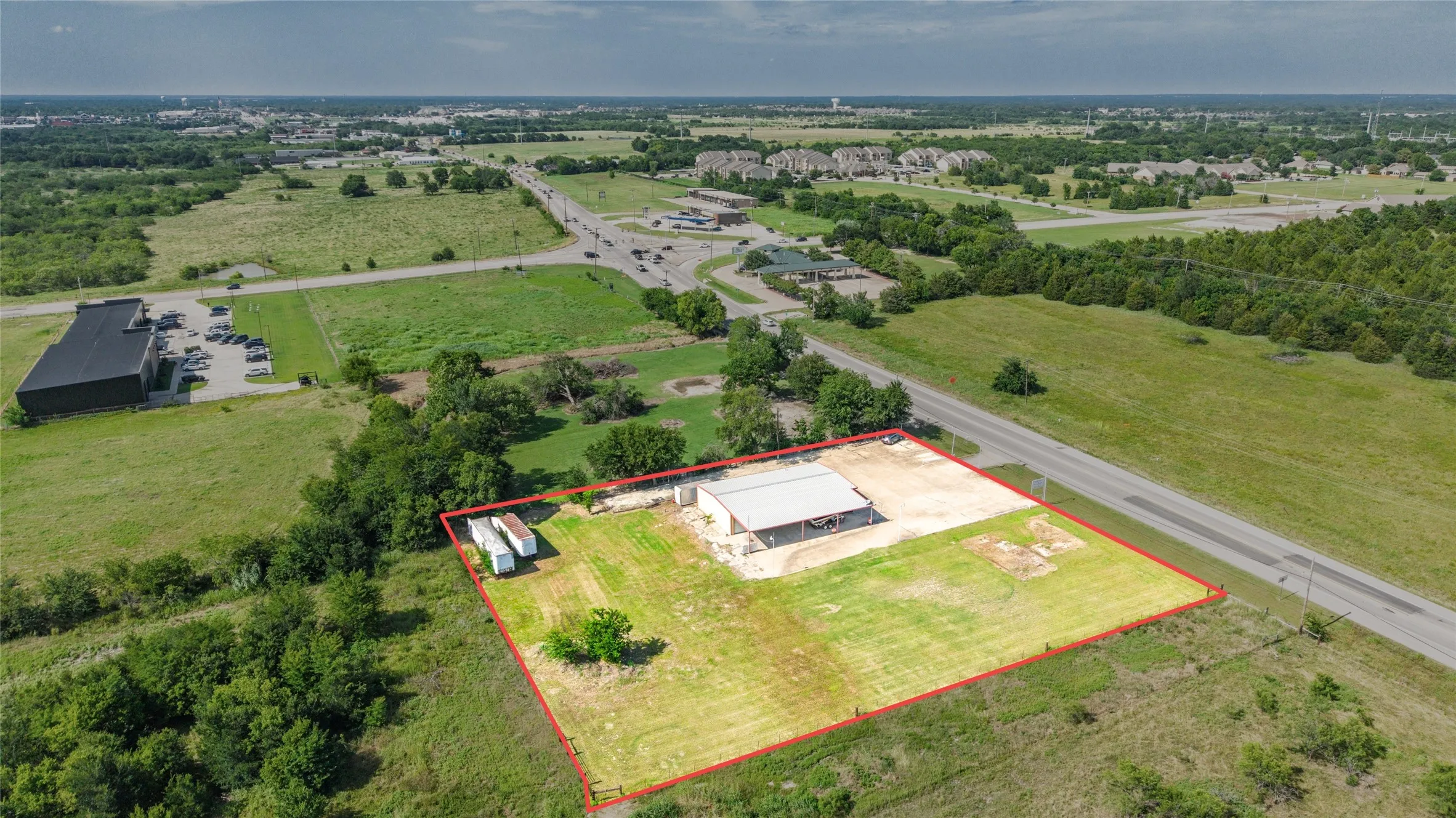 Expansive commercial property featuring a large open-air structure with a metal roof