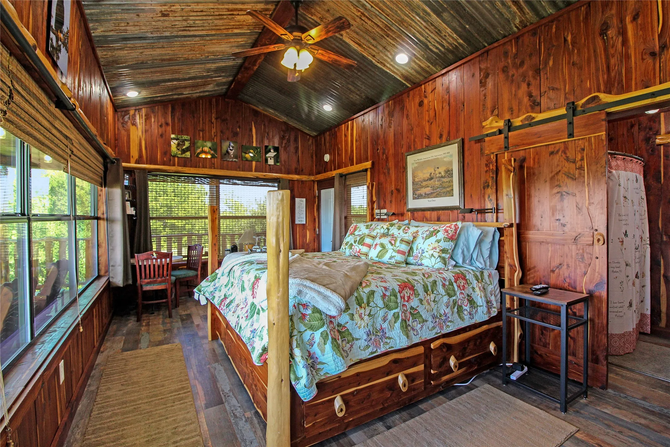 Vaulted ceiling with wood-paneled walls and a ceiling fan