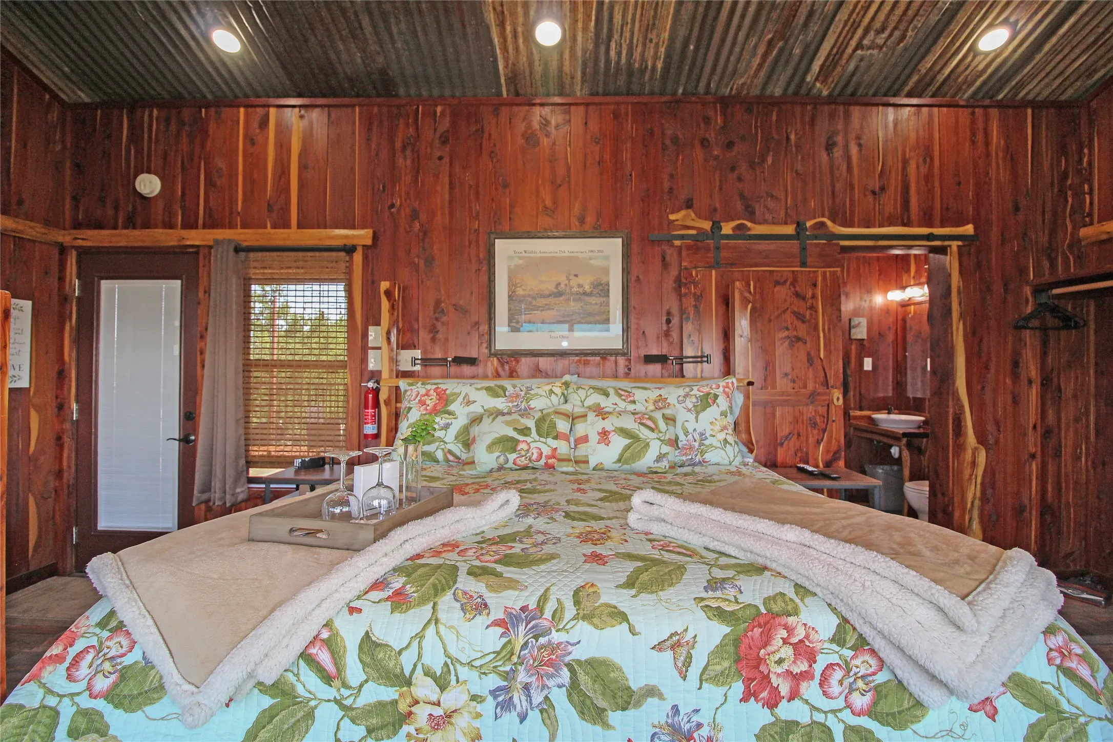 Wood-paneled room featuring a corrugated metal ceiling with recessed lighting
