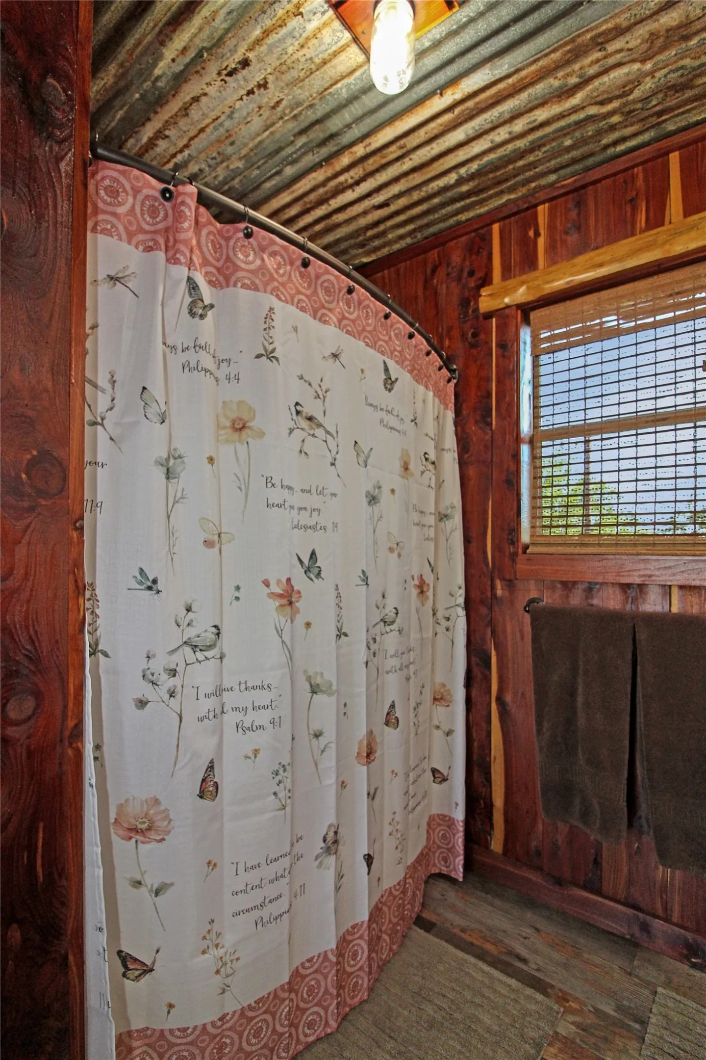 Bathroom featuring wood paneling, corrugated ceiling, and a window with blinds