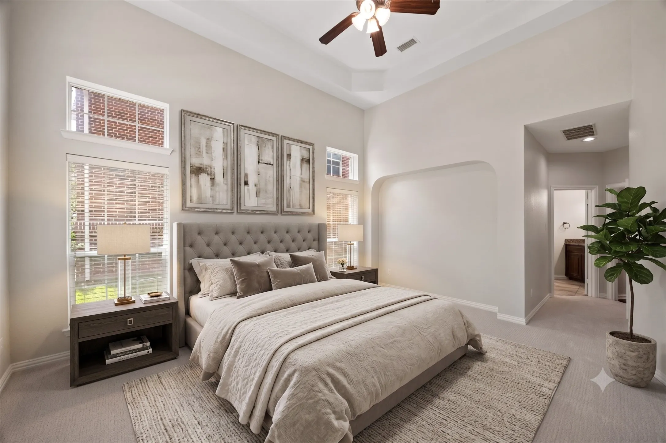 Spacious bedroom featuring high vaulted ceilings, light-toned carpeting, and multiple windows with blinds
