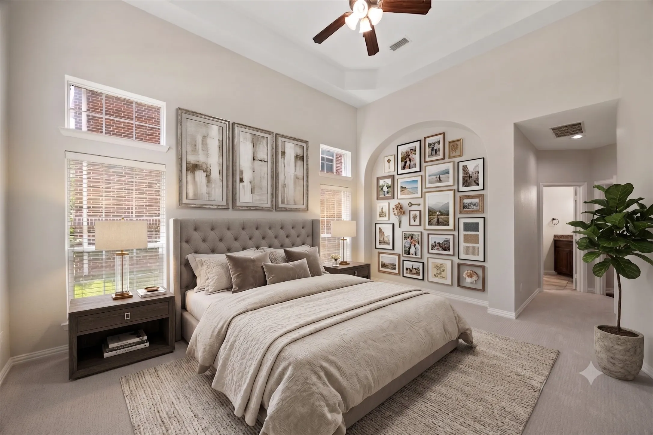 Virtually staged - Primary Bedroom featuring an arched wall recess, tray ceiling, and a ceiling fan with integrated lighting
