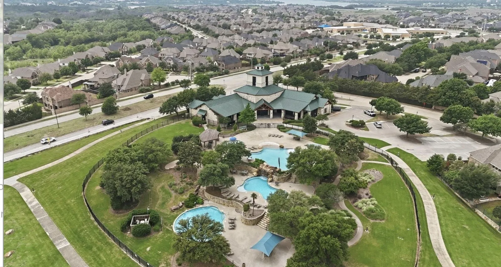 Community clubhouse with multiple swimming pools and surrounding residential properties