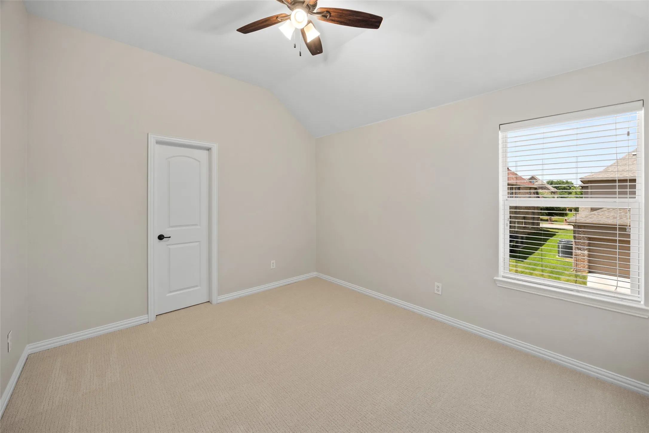 Carpeted room featuring a vaulted ceiling and a ceiling fan