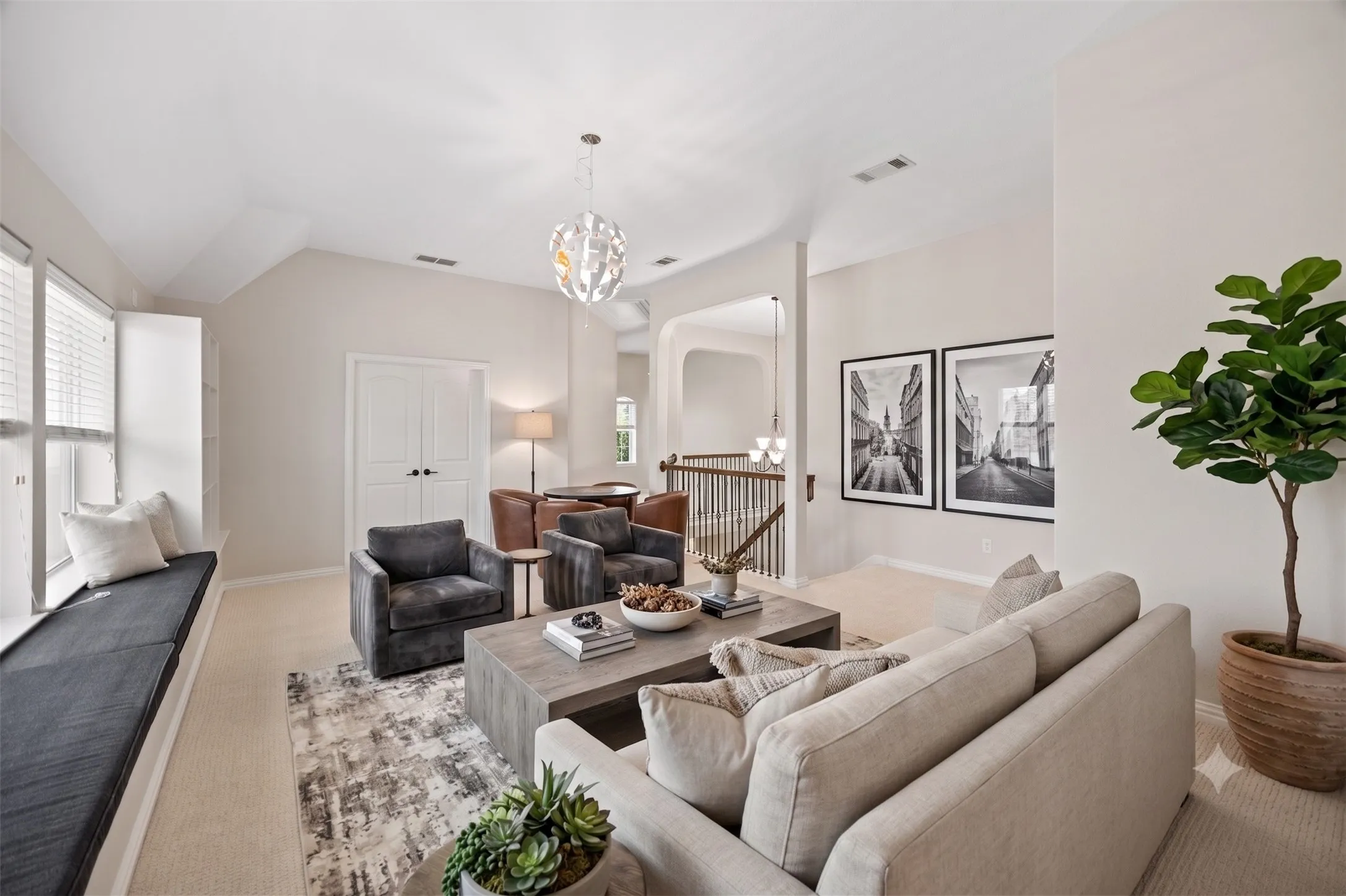 Virtually staged - Vaulted ceiling living area featuring a large window seat, a contemporary chandelier, double panel doors, and carpet flooring