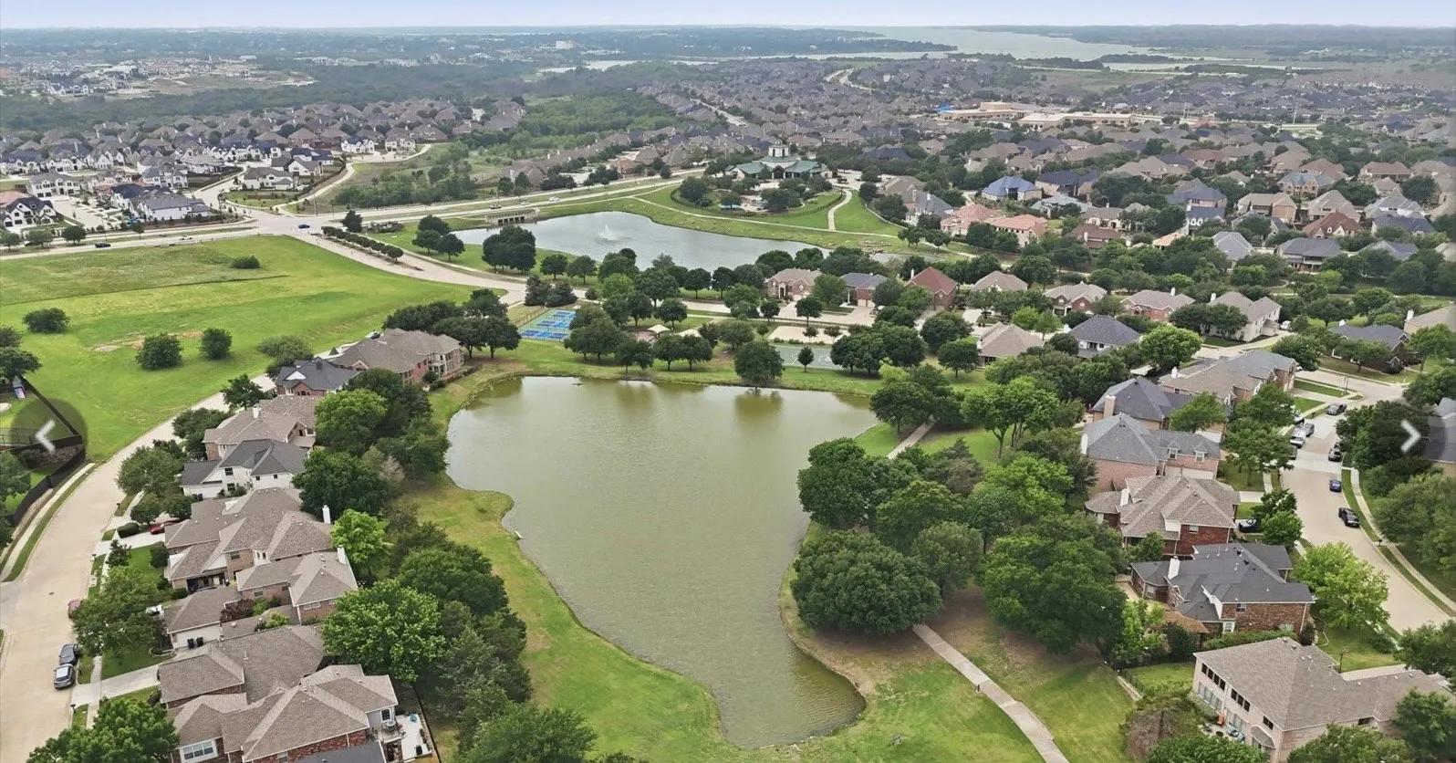 Residential community featuring multiple lakes, green spaces, and mature tree coverage