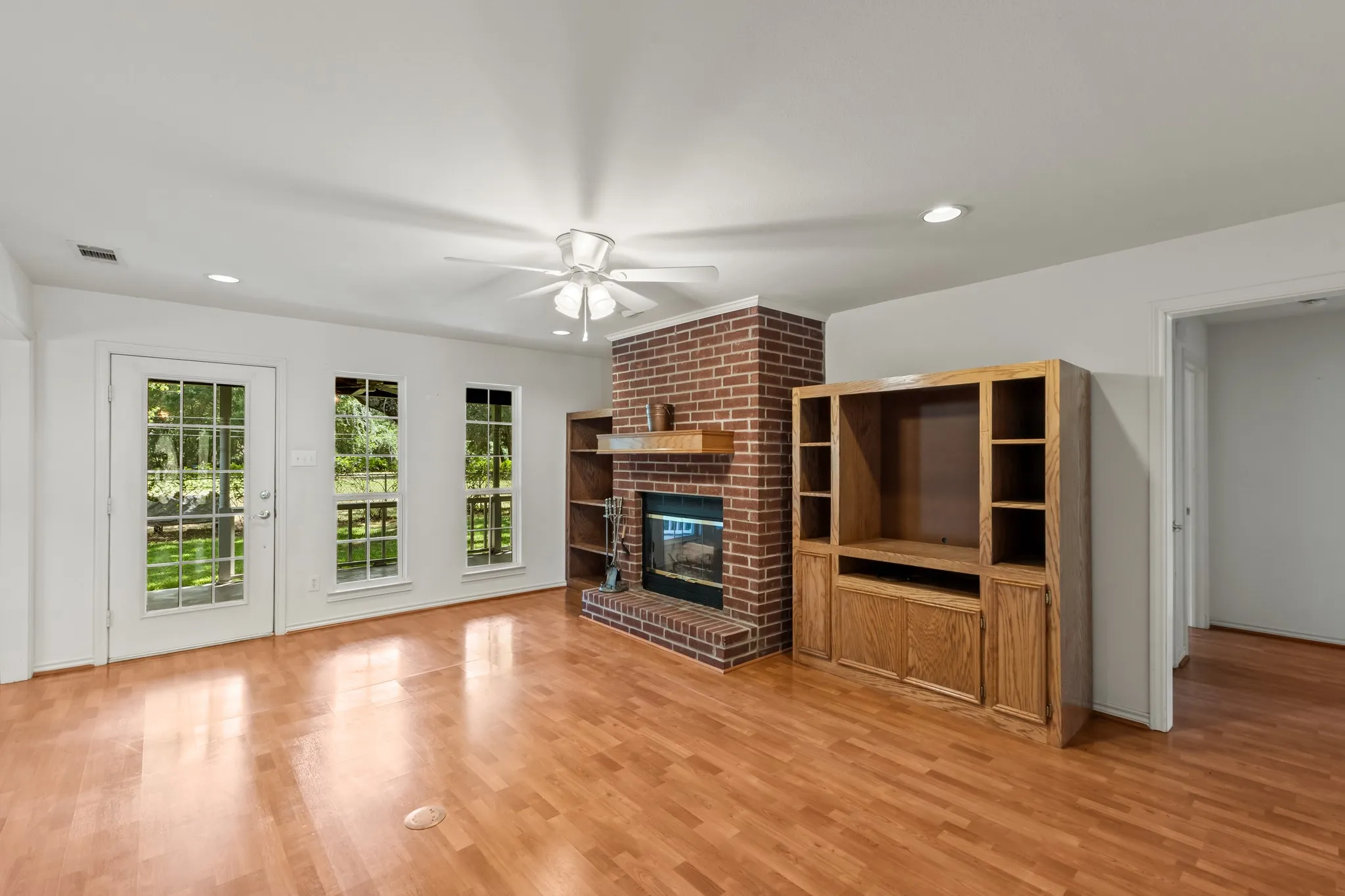 Spacious living area with abundant natural light with door leading to the covered back porch. Cabinets are not attached and can be removed if desired.