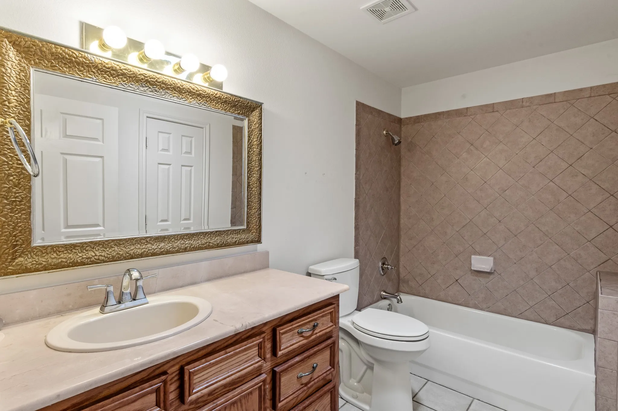 Full guest bathroom featuring a tile tub and shower combination.