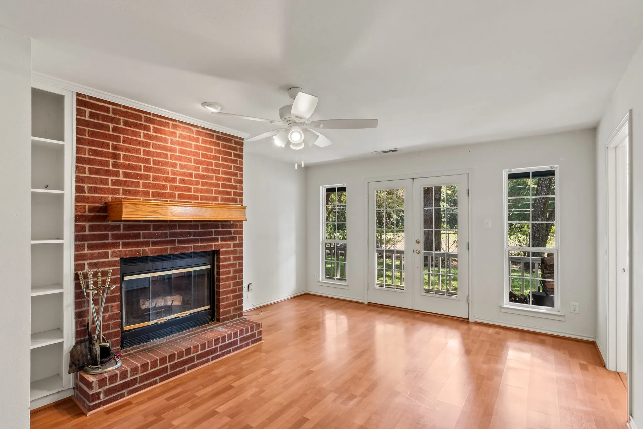 Spacious primary bedroom featuring its own fireplace and private double door access to the covered back porch.