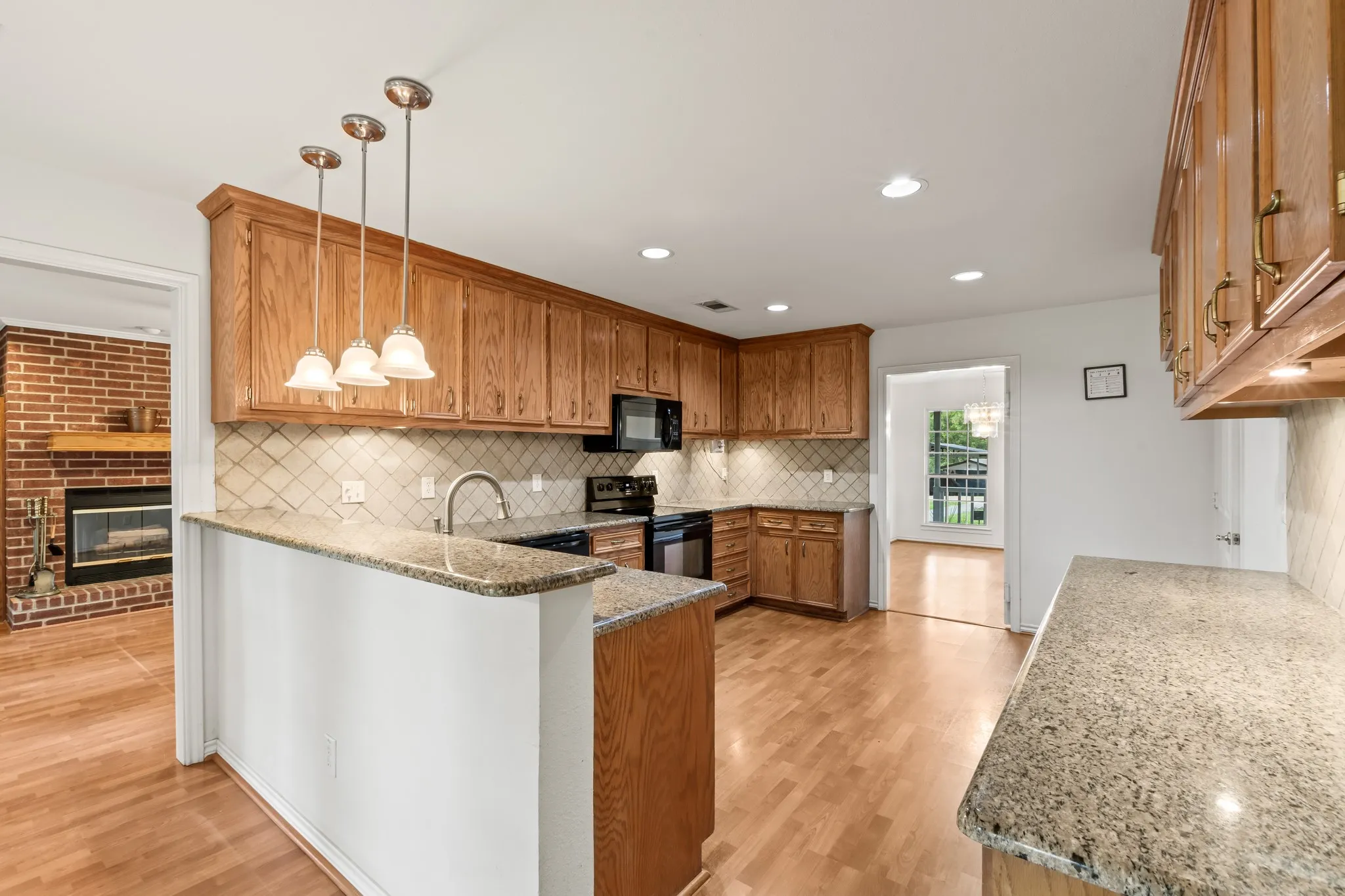 Spacious kitchen featuring granite countertops, rich wood cabinetry, and built-in wine storage.