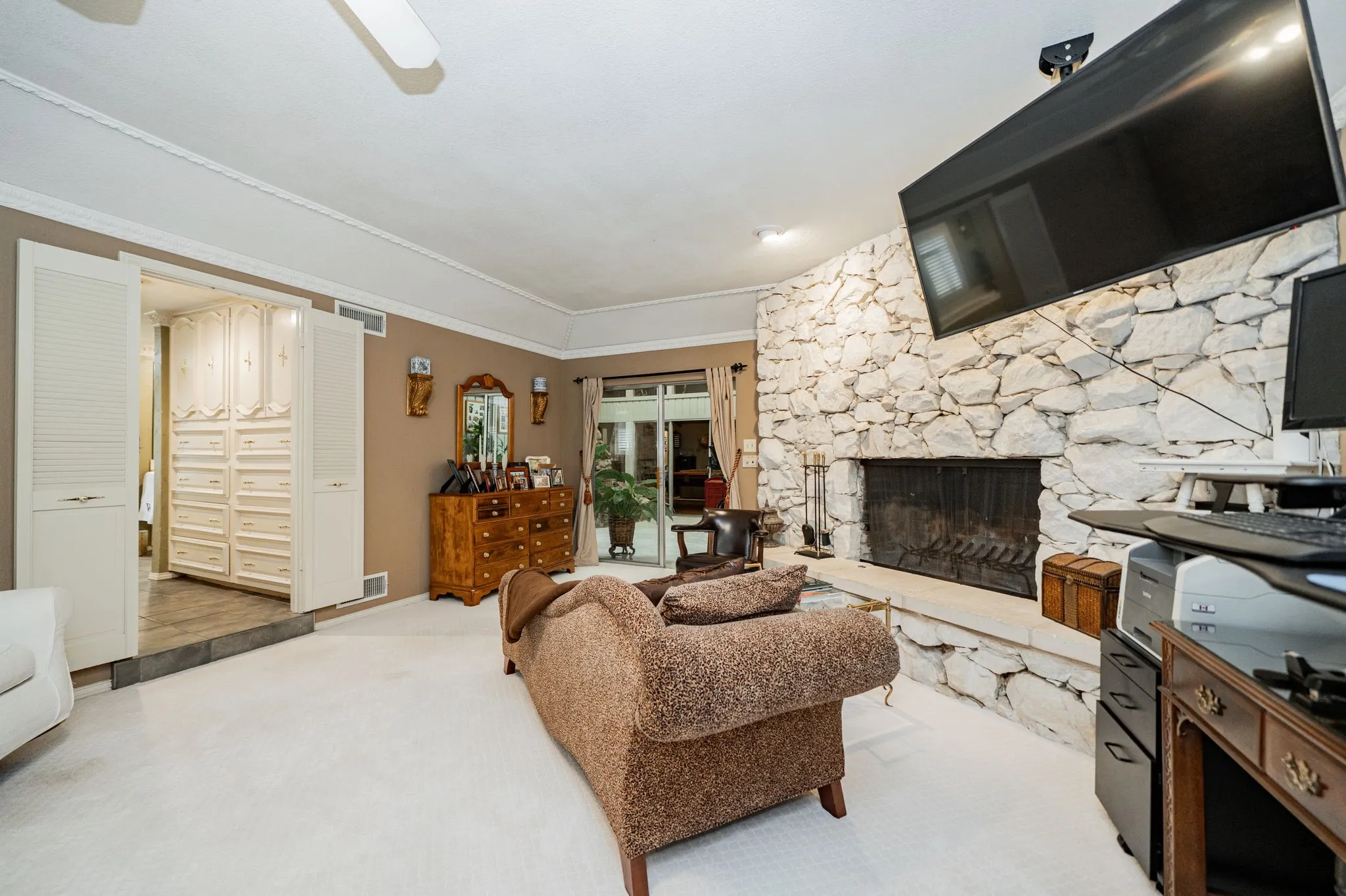 Carpeted living area featuring a fireplace and ornamental molding