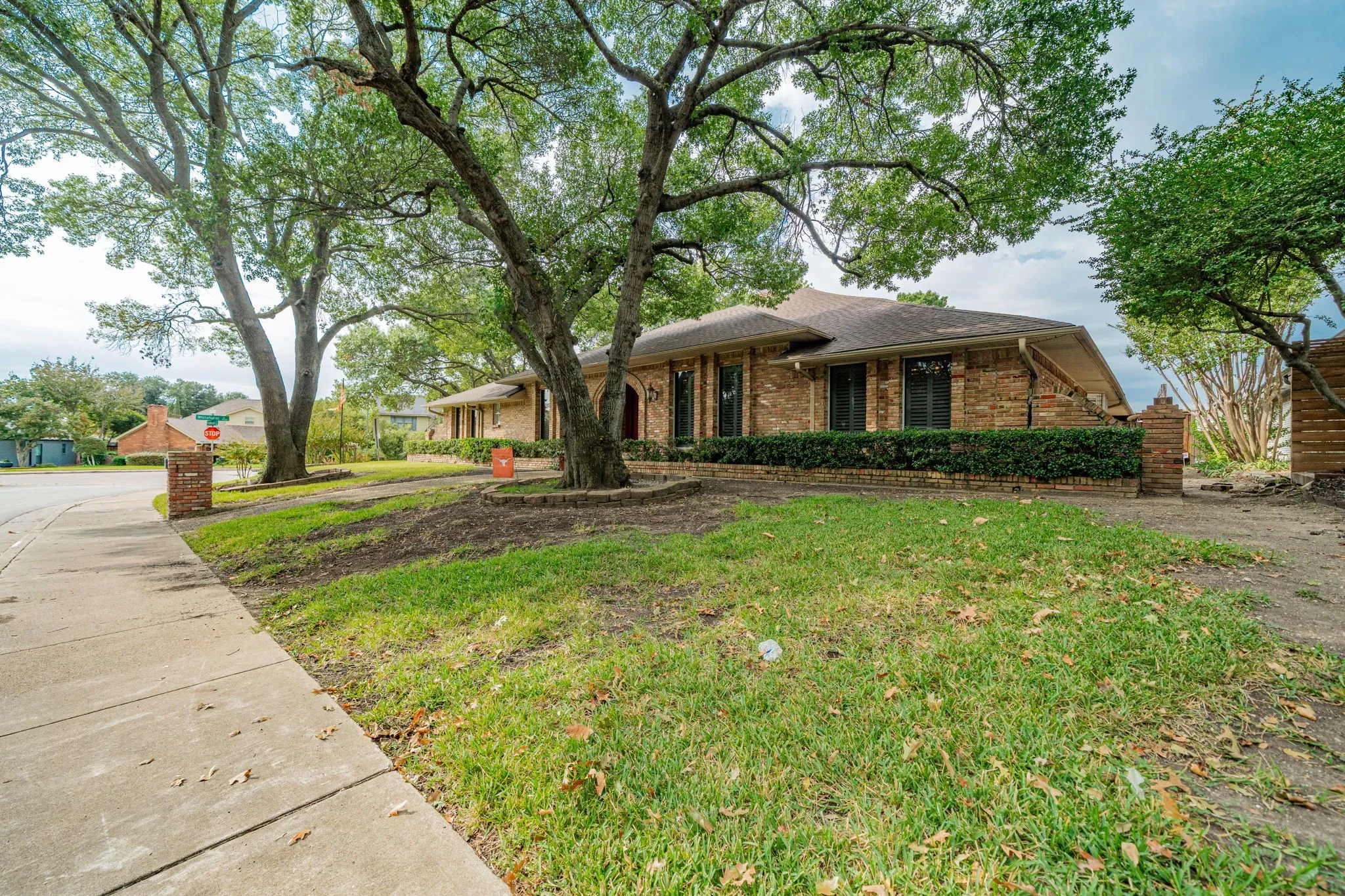 Ranch-style home featuring a front lawn, brick siding, and a shingled roof