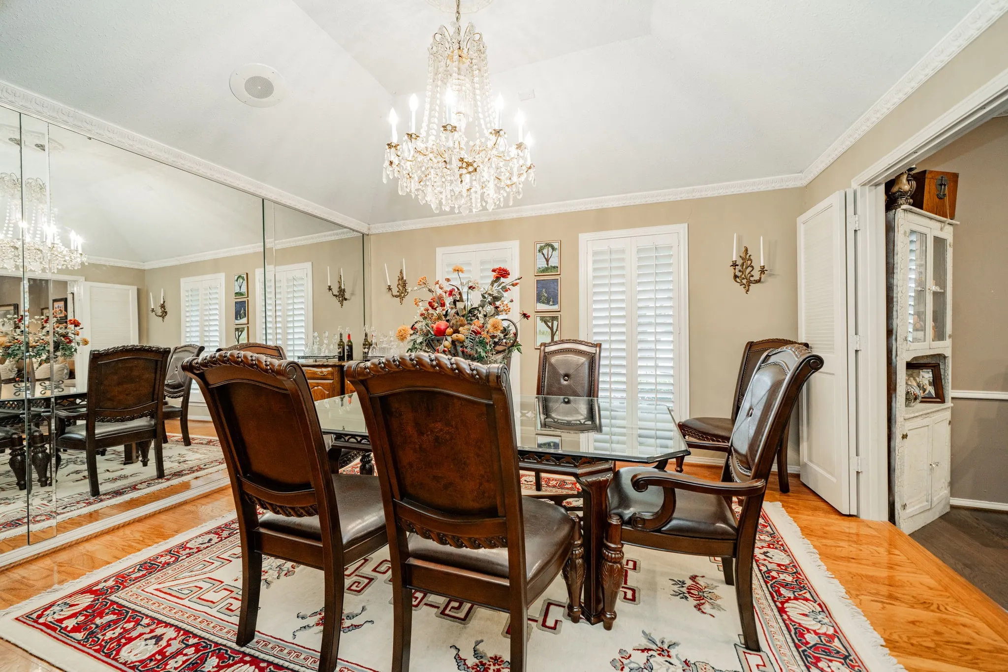 Dining space featuring a chandelier, wood finished floors, lofted ceiling, and ornamental molding