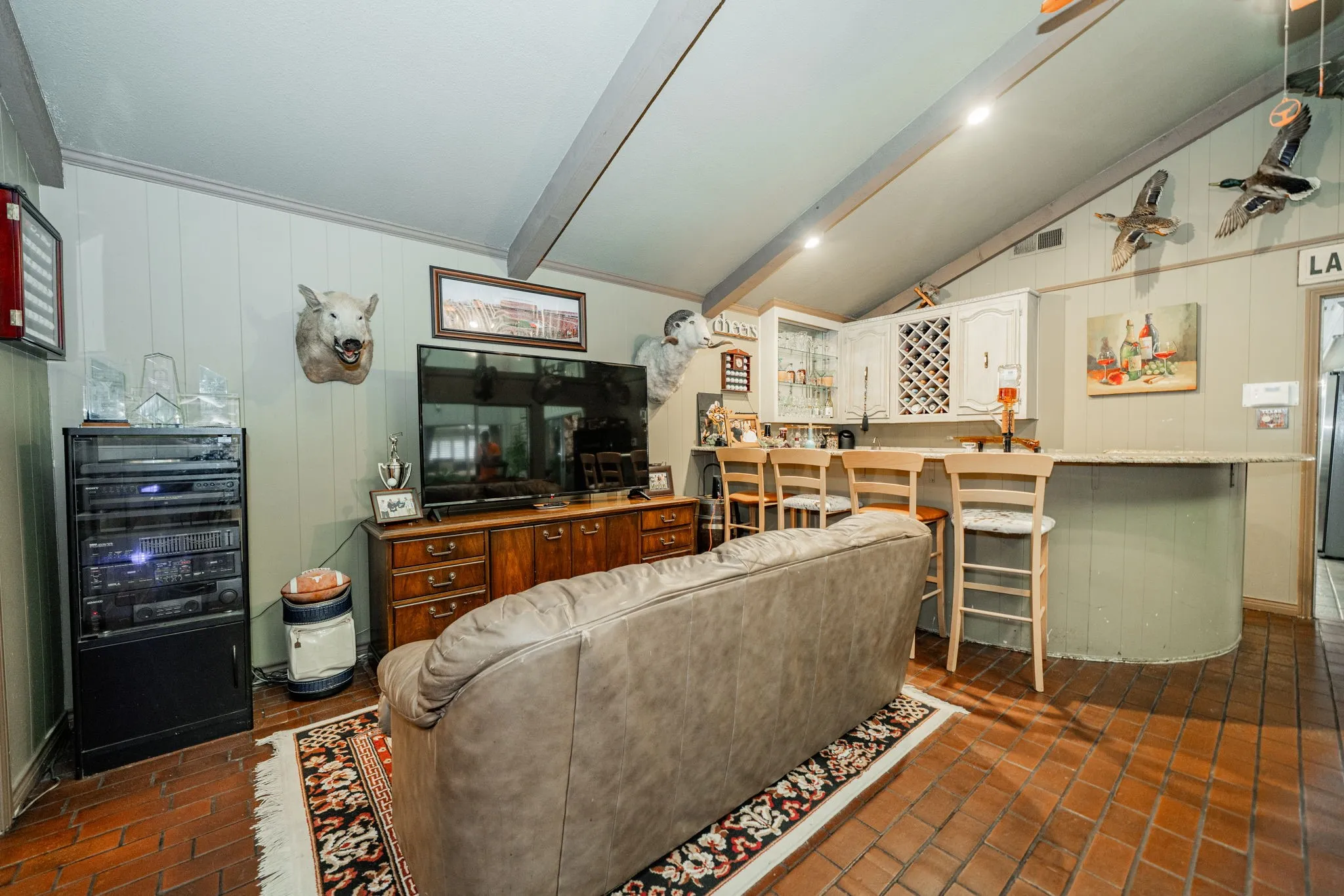 Living room featuring wooden walls and brick floors