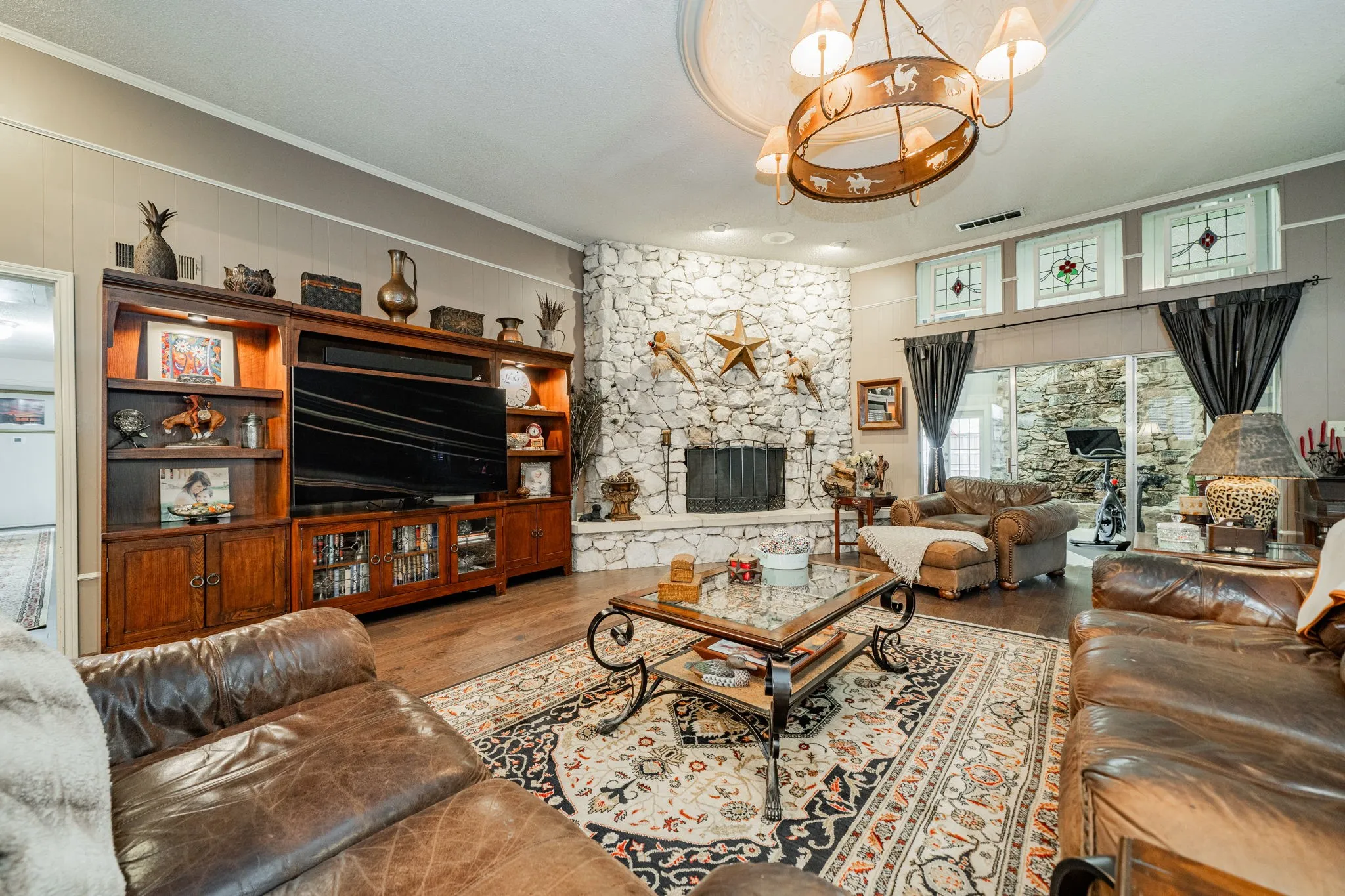 Living area with ornamental molding, a fireplace, wood finished floors, and a chandelier