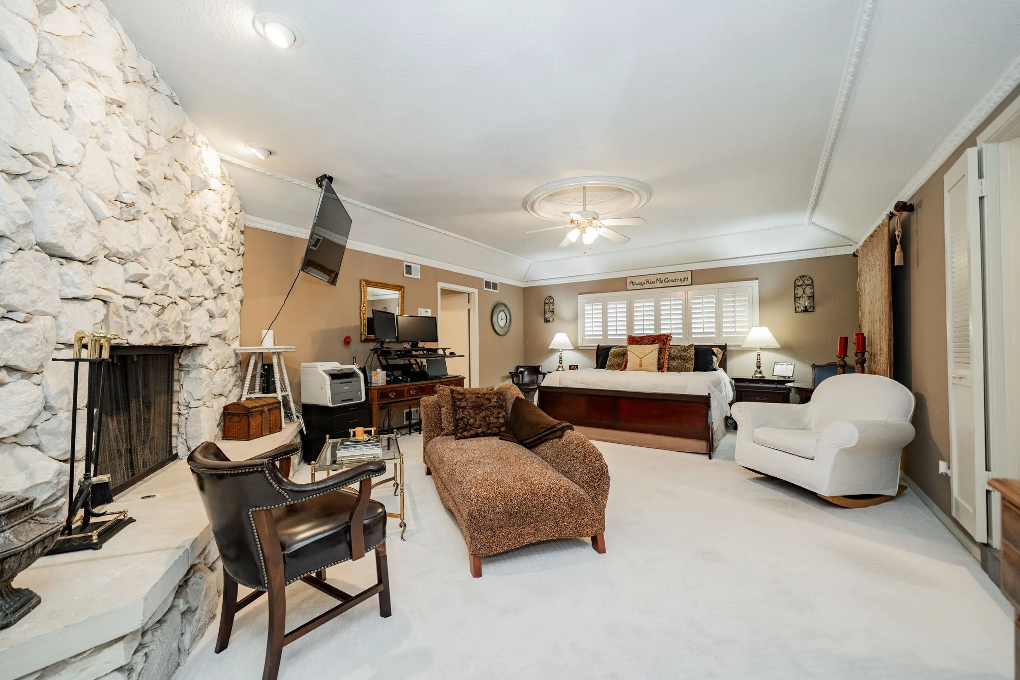 Living room featuring crown molding, a fireplace, carpet, and a ceiling fan