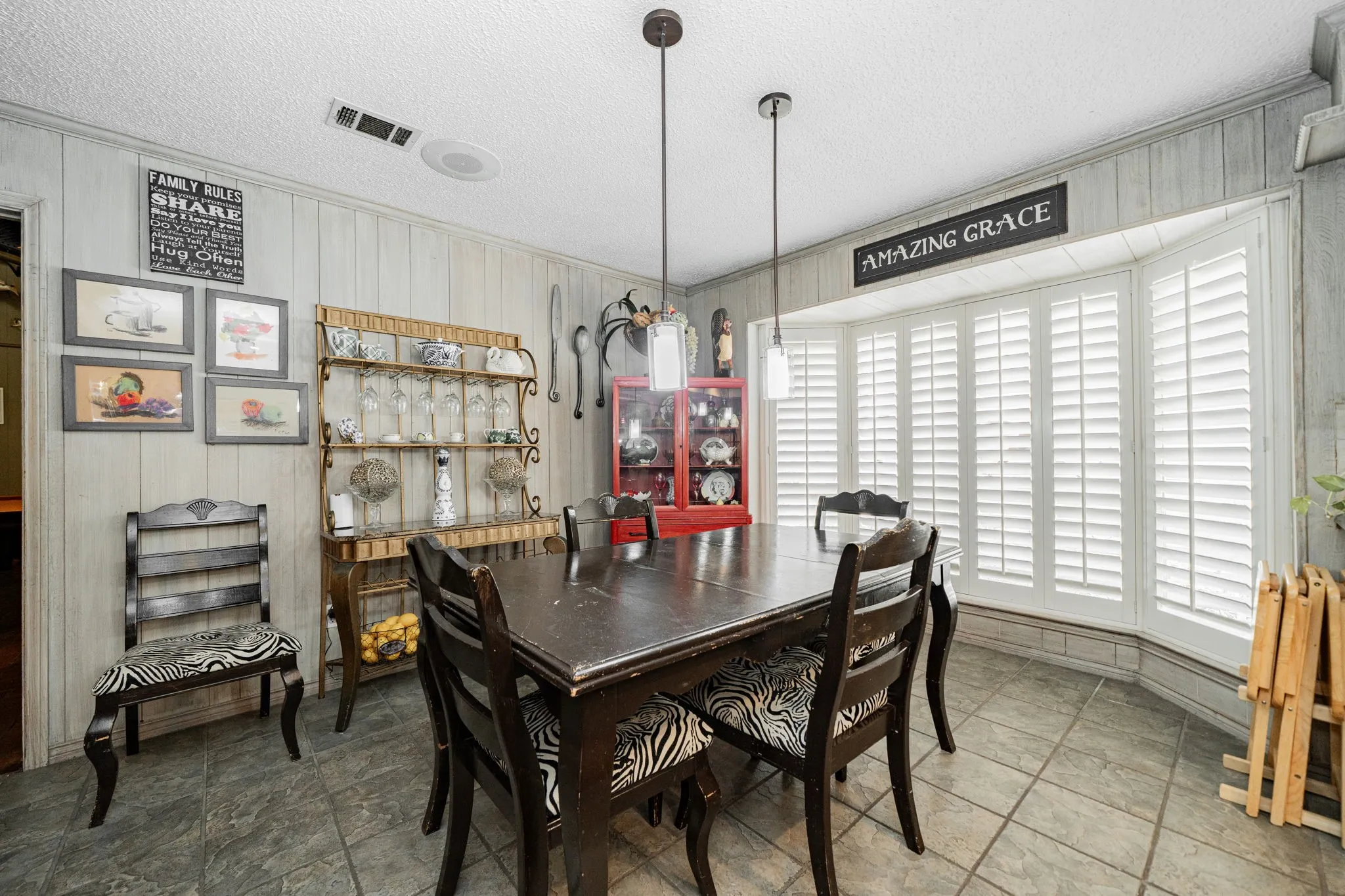Dining room with wood walls, a textured ceiling, and crown molding