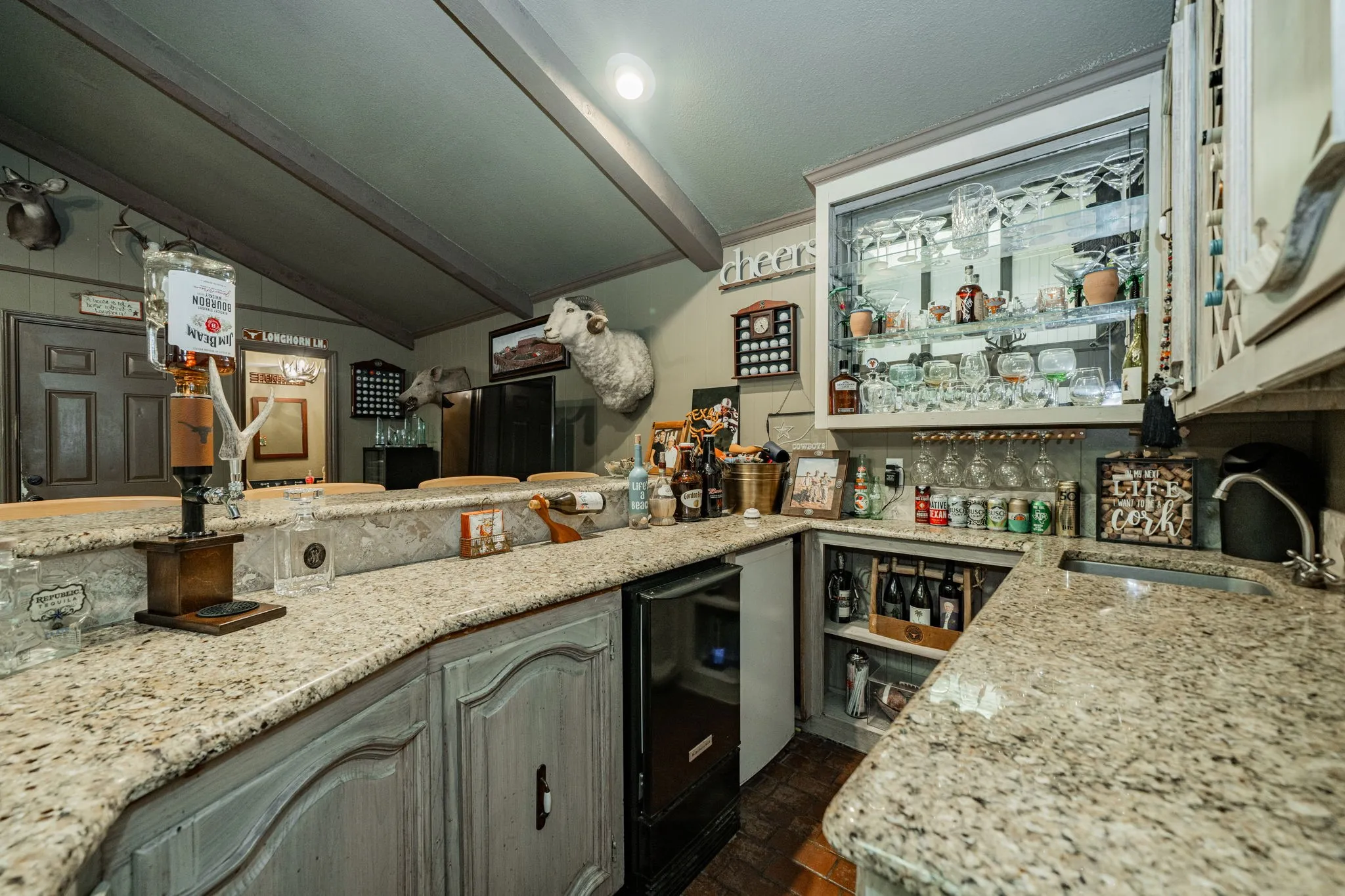Indoor bar with light stone counters, brick floors, and open shelves