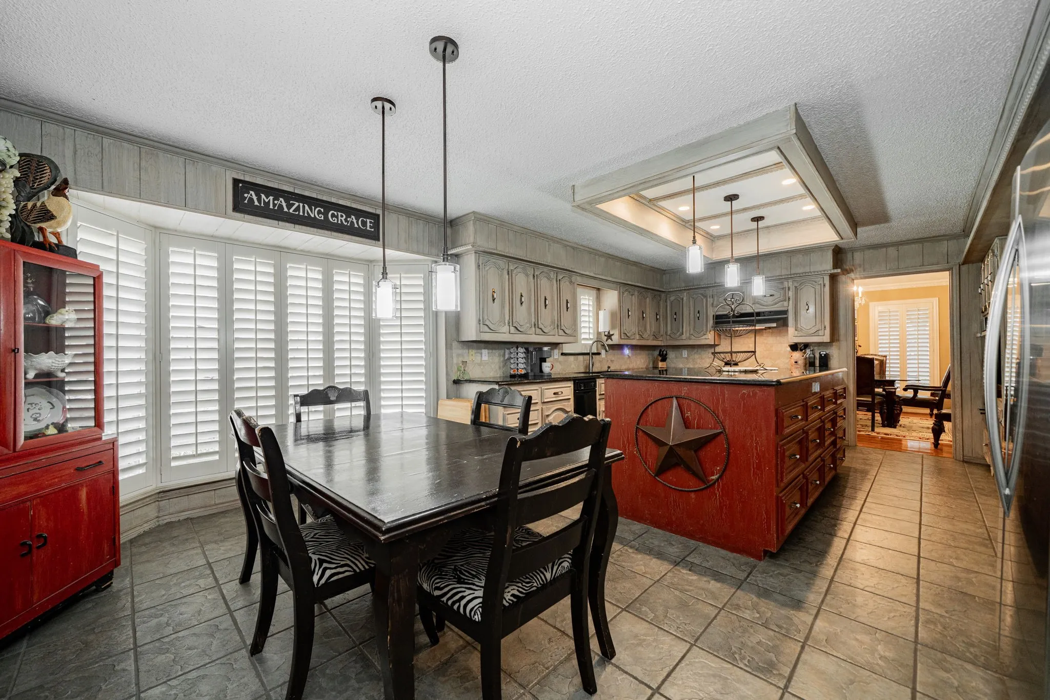 Dining area with a tray ceiling, a textured ceiling, and wood walls