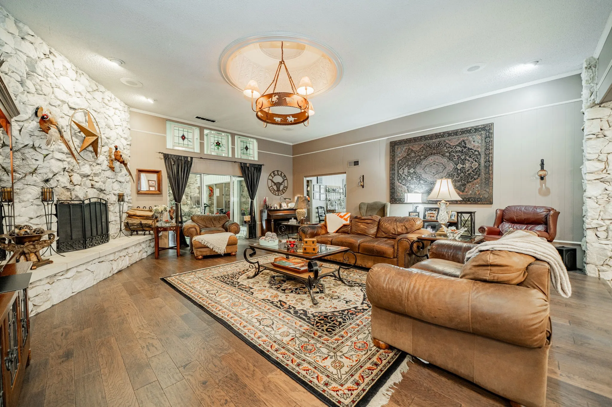 Living area featuring a fireplace, hardwood / wood-style flooring, ornamental molding, and a chandelier