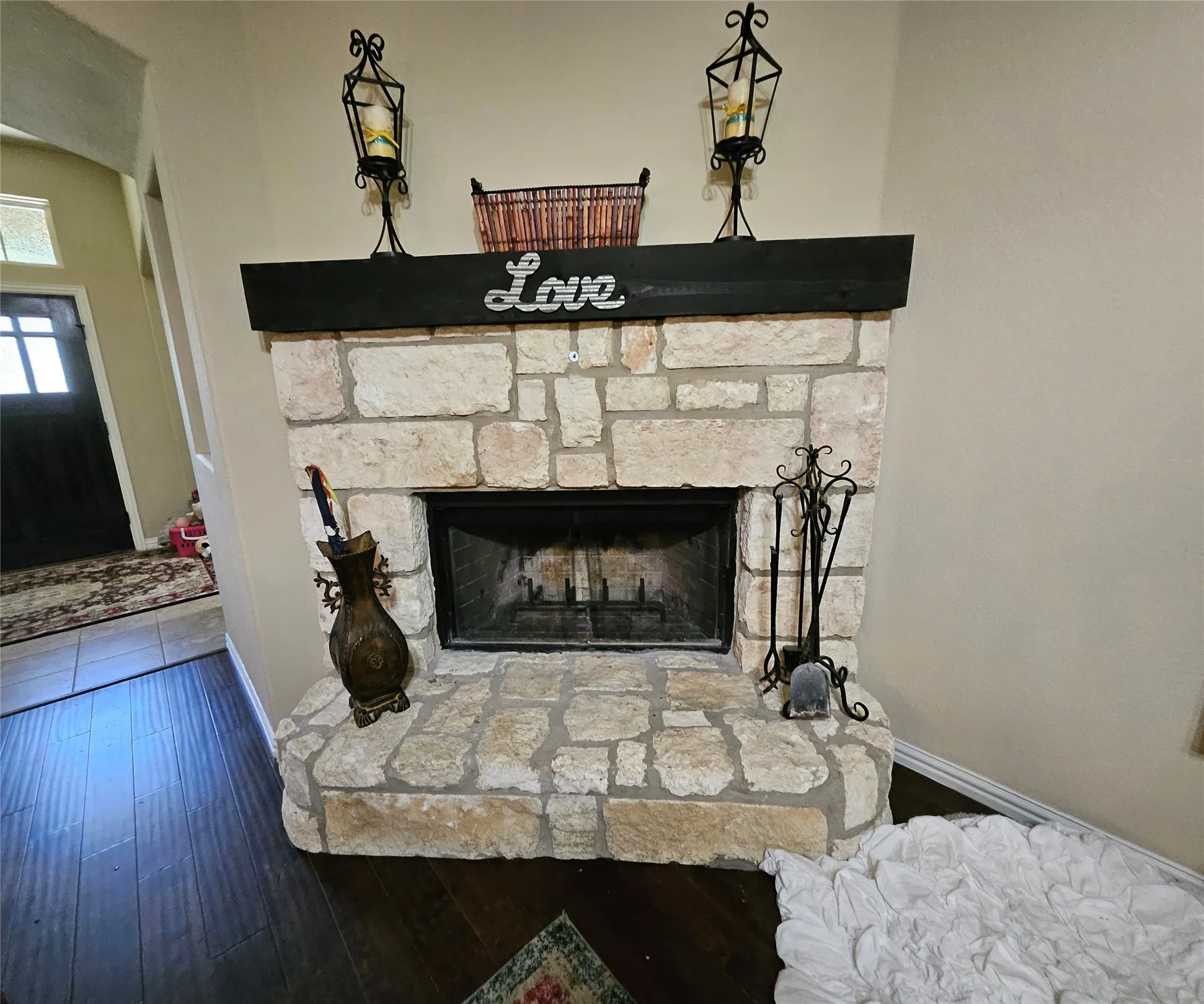 Stone fireplace featuring a dark wood mantel and a stone hearth