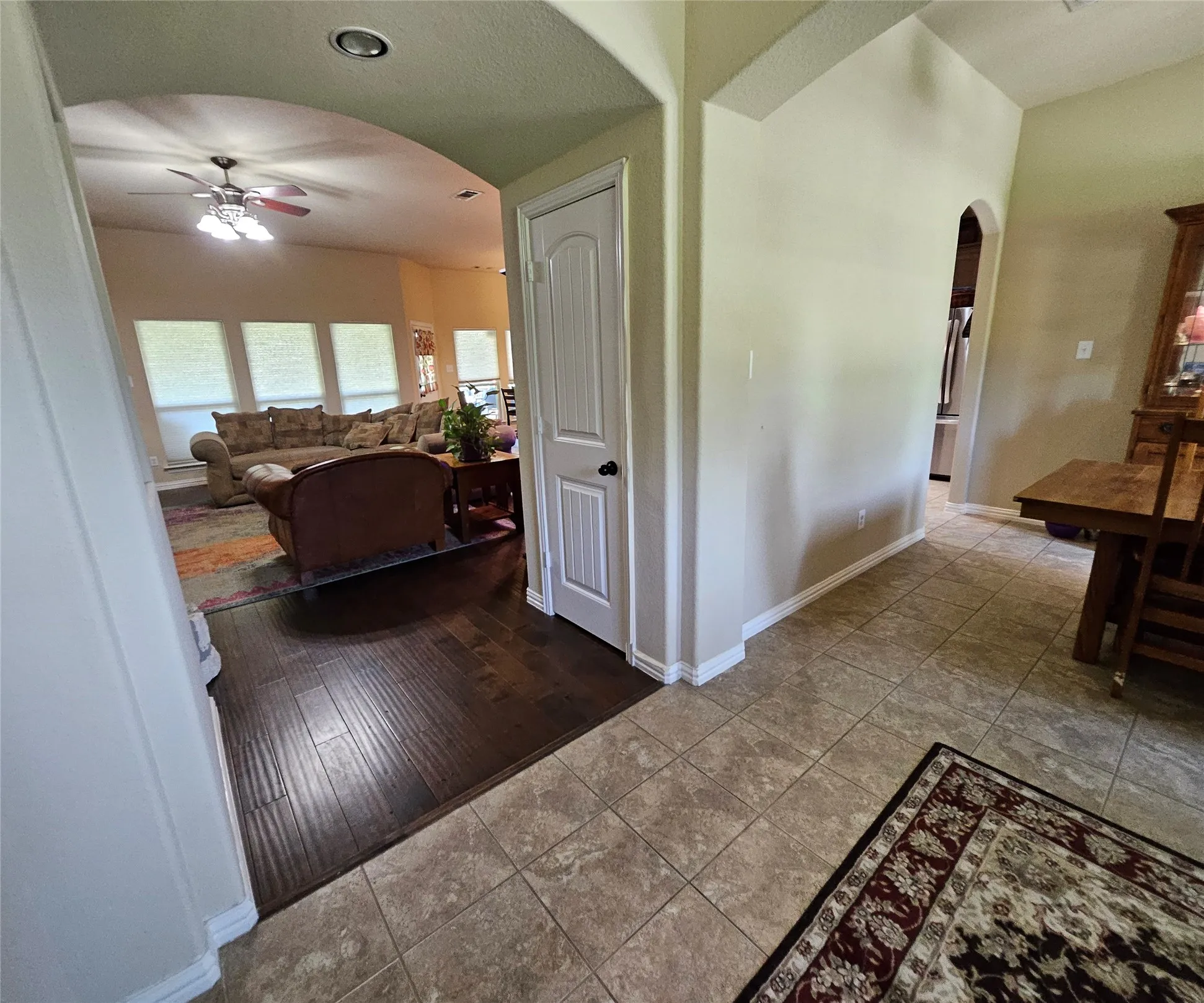 Archway entry to a living area featuring wood-finish flooring