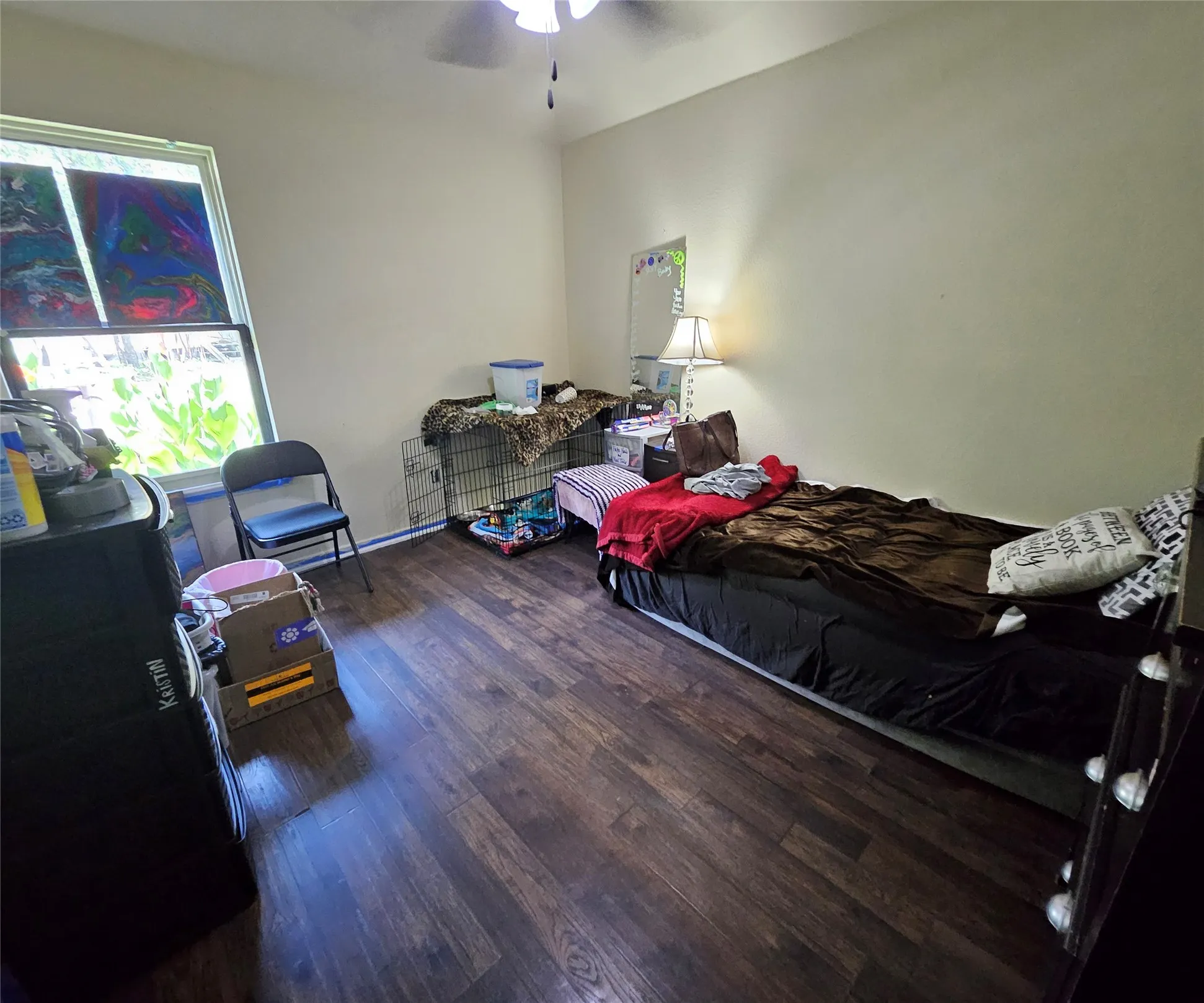Room featuring wood-finish flooring, a window, and a ceiling fan