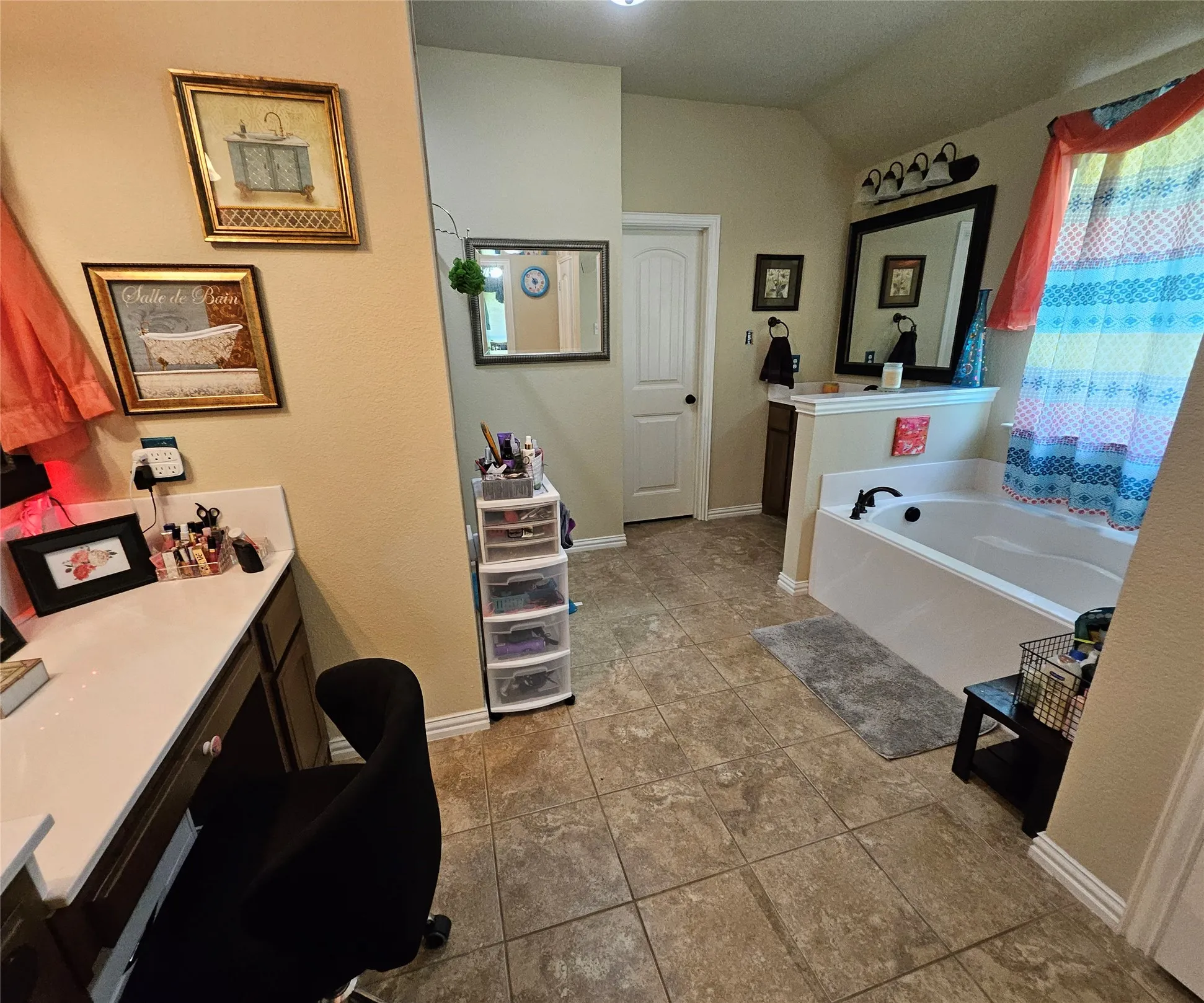 Spacious bathroom featuring an integrated soaking tub, separate vanity with storage, tile flooring, and a second vanity area