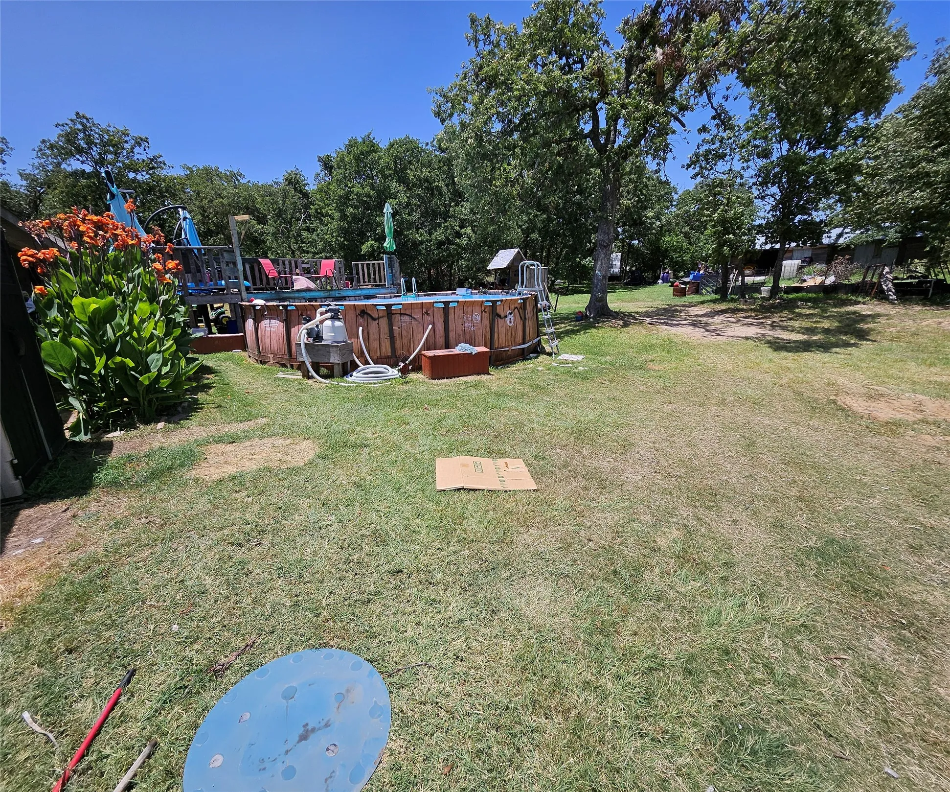 Above-ground pool with wood-finish siding and a surrounding deck structure