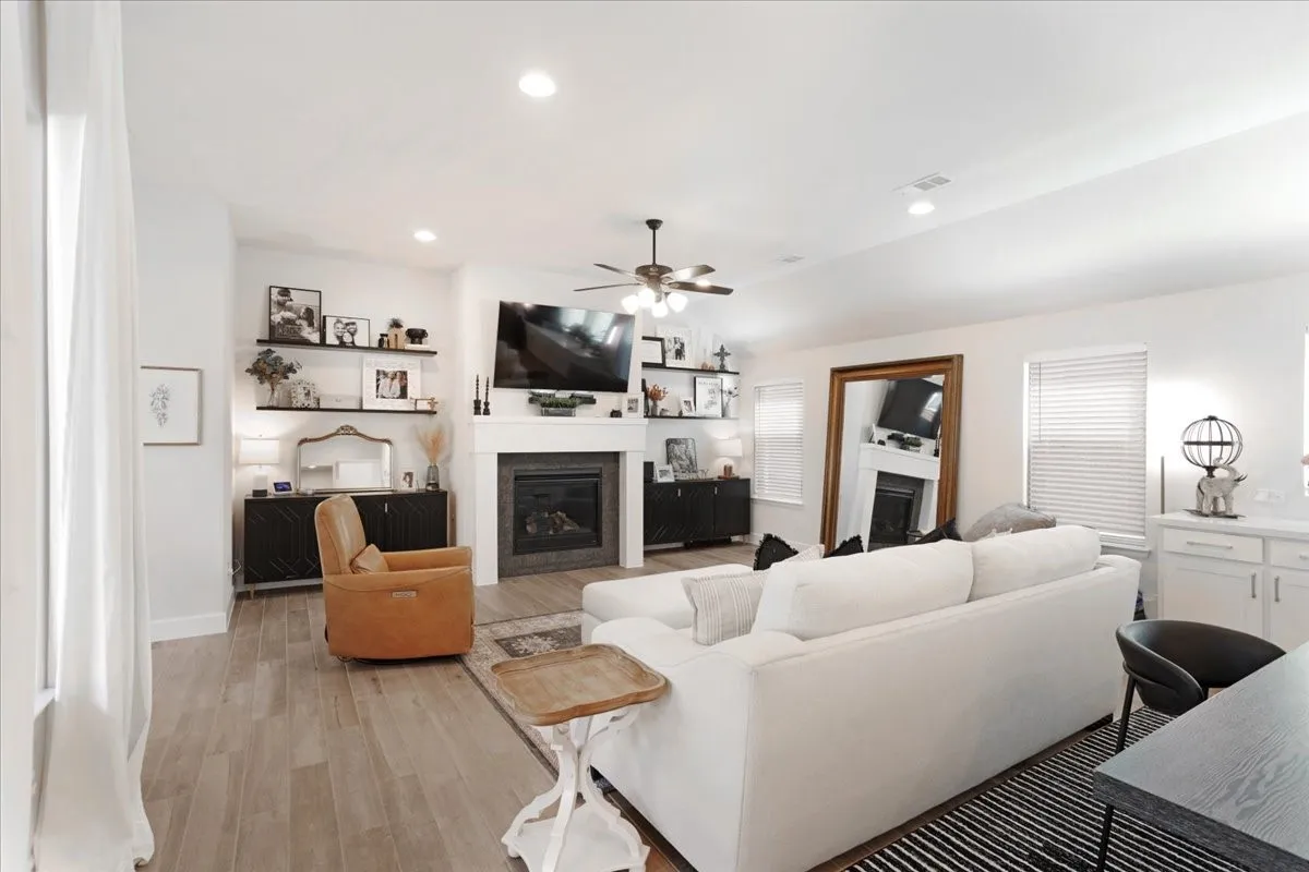 The kitchen looks over the living area that also has a beautiful fireplace with a wood mantel.