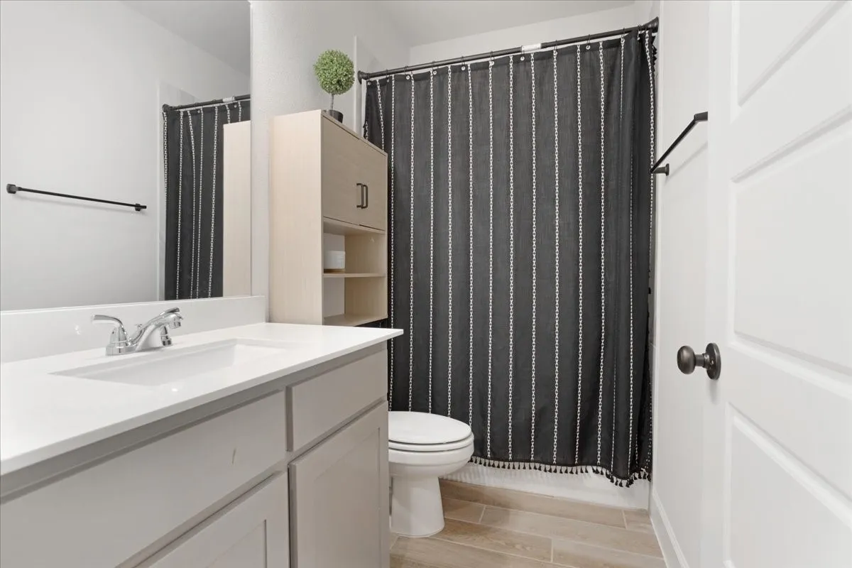 Guest bath with tiled floors and painted vanity.