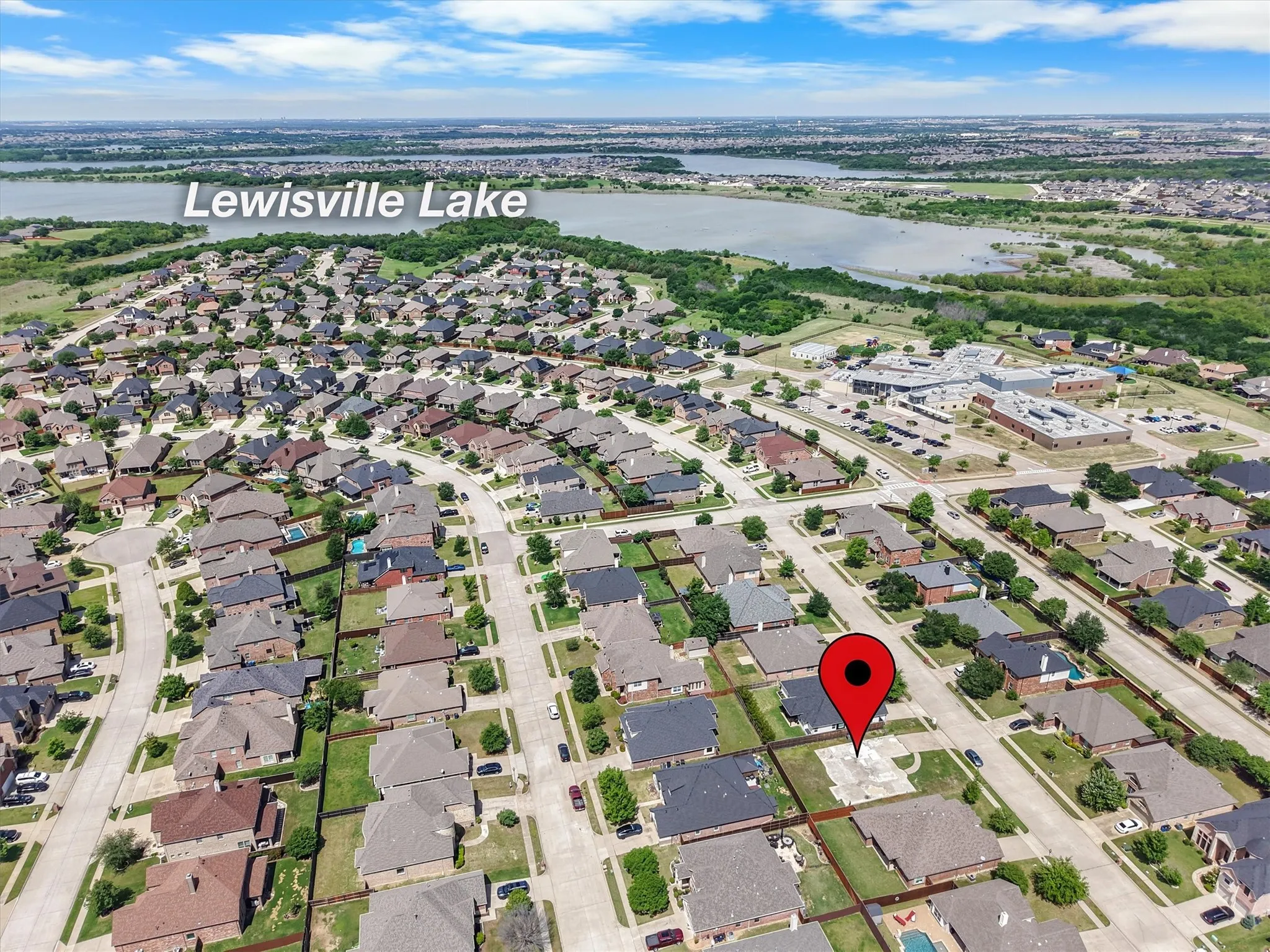 Aerial perspective showcasing a residential neighborhood with Lewisville Lake in the background