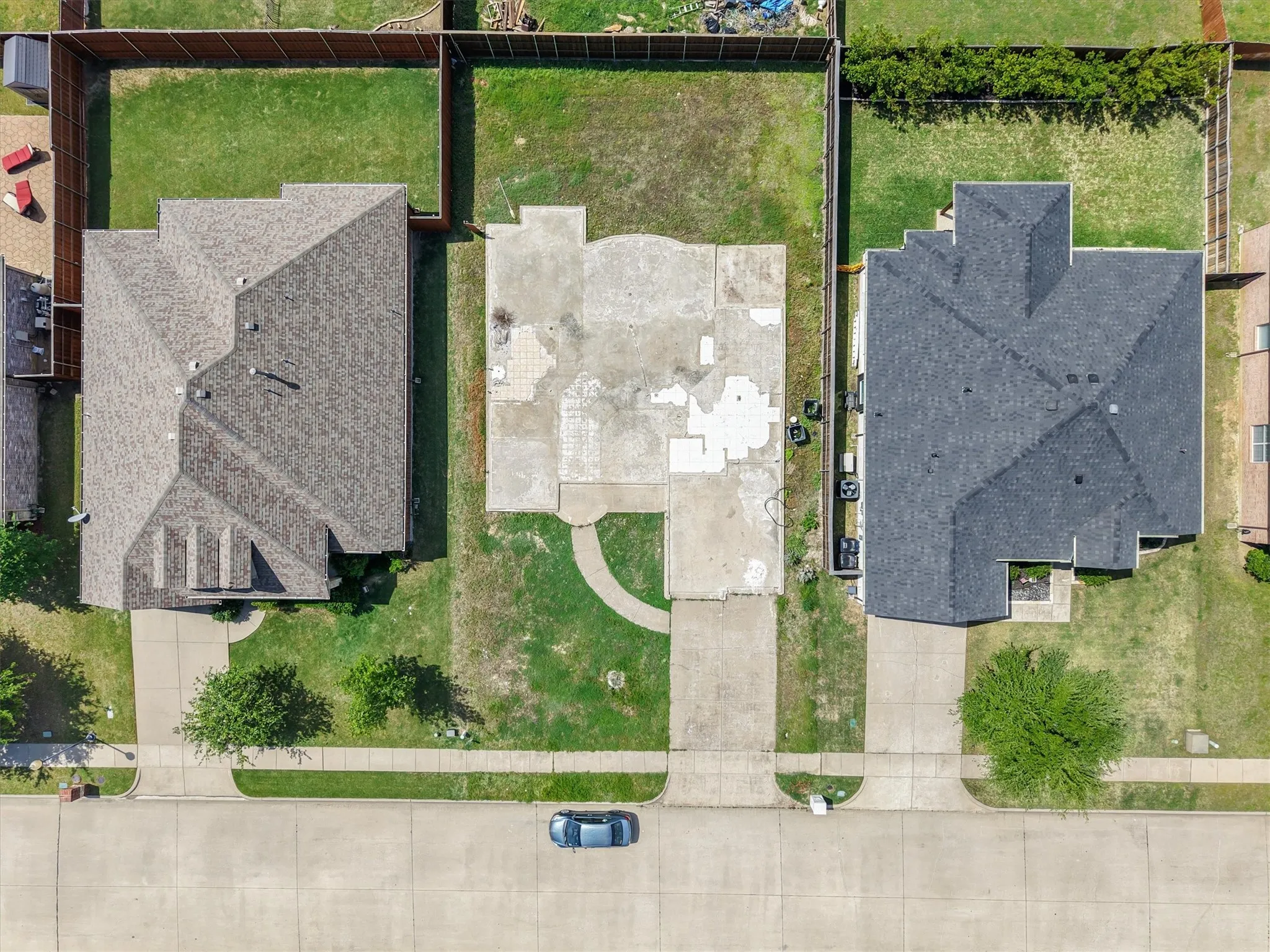 Overhead view of a residential property featuring a partially developed concrete foundation, a concrete driveway, and a front walk