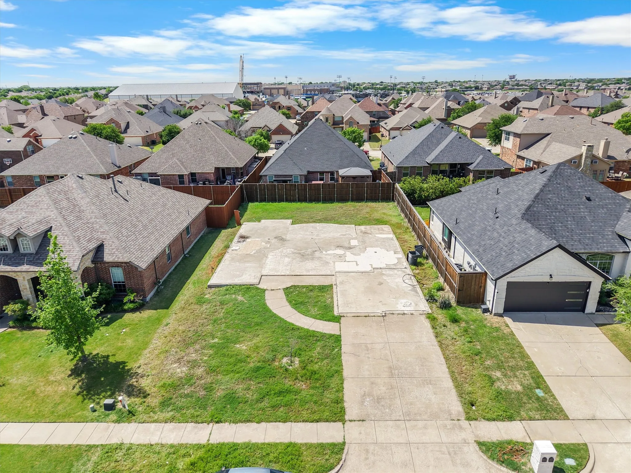 Residential lot featuring a concrete foundation and driveway, surrounded by established homes