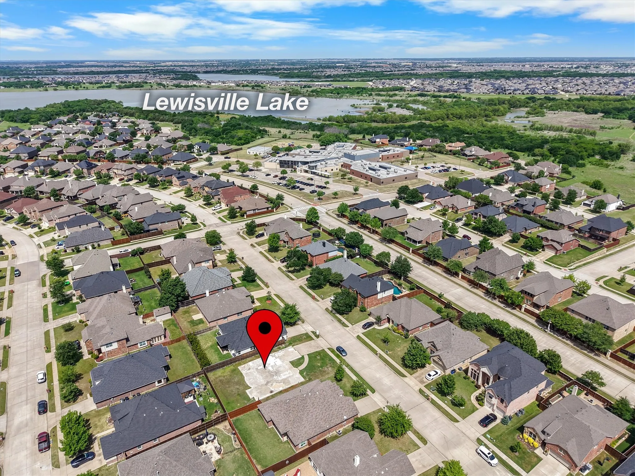 Aerial overview of a residential neighborhood with Lewisville Lake in the background