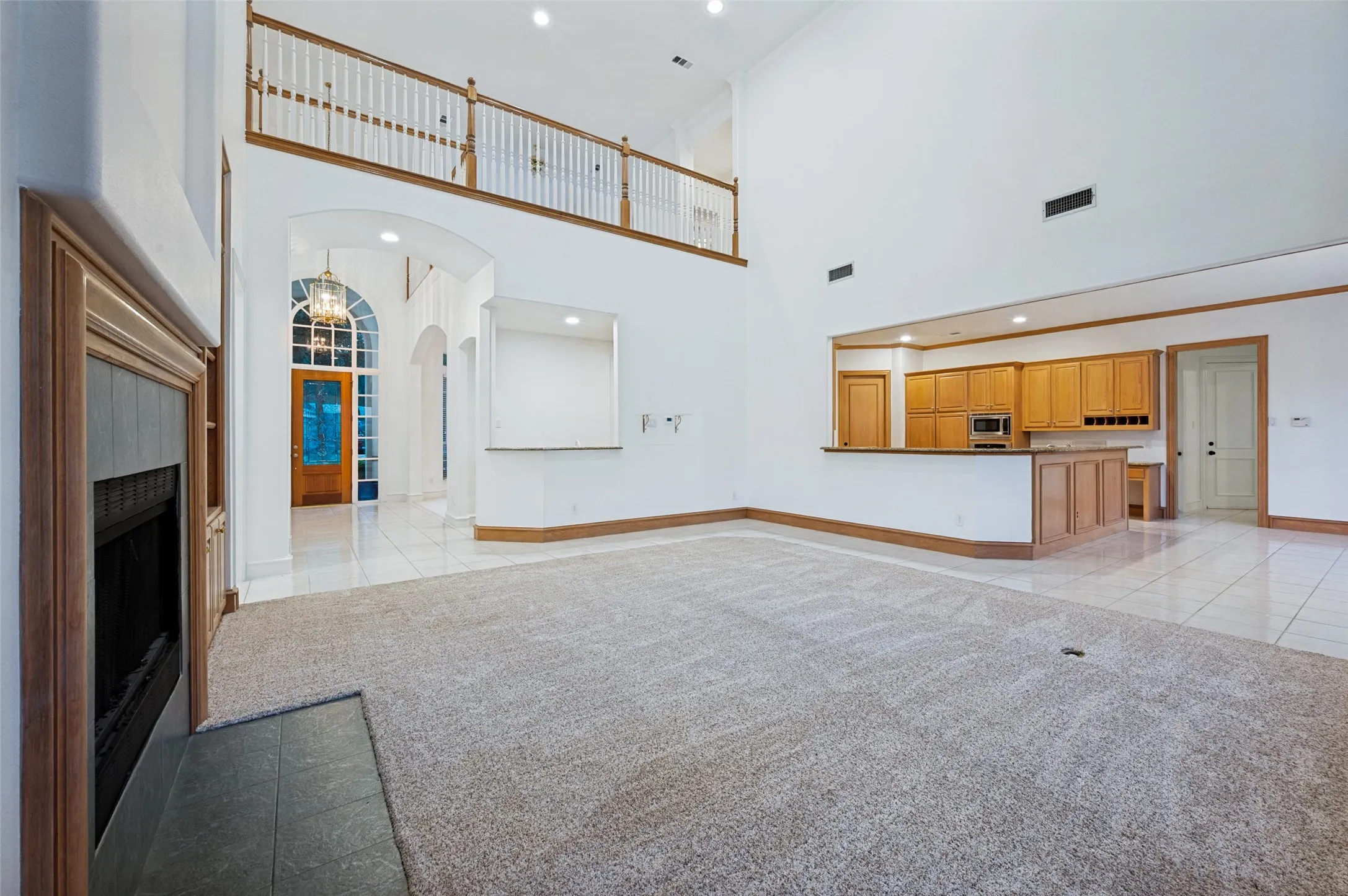 Expansive living area featuring soaring ceilings and light-toned carpeting